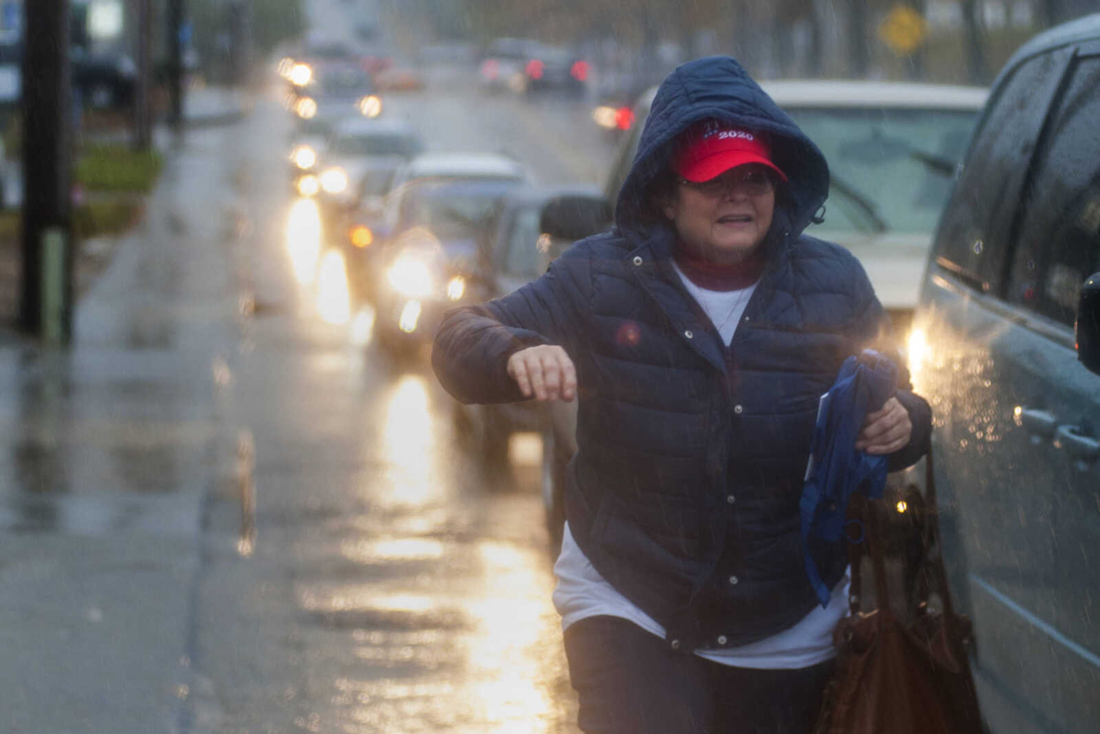 A woman exits her car in heavy rain to take a place in line outside the Show Me Center Monday.