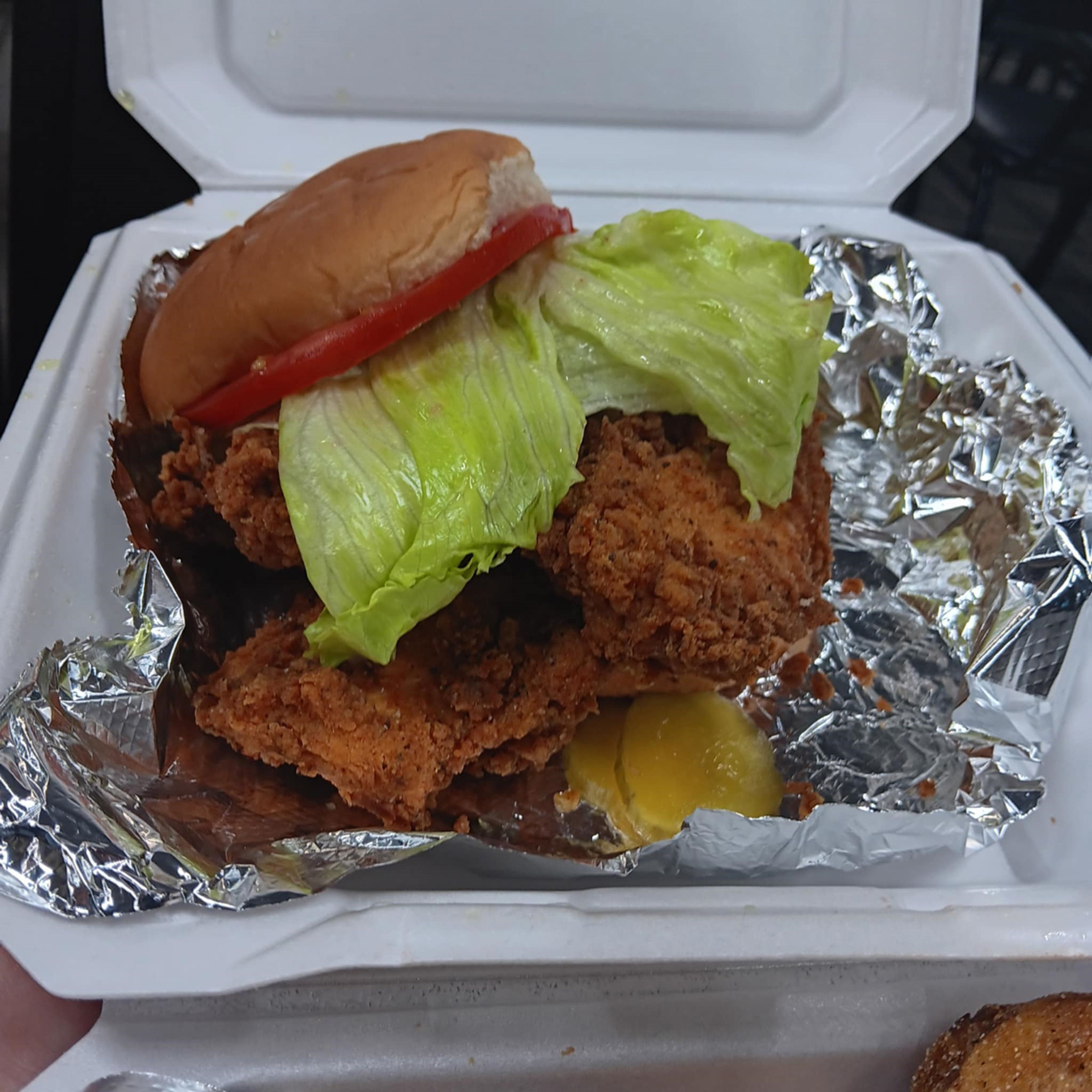 Fins & Feathers monstrous chicken sandwich, spilling off of the bun from all directions.