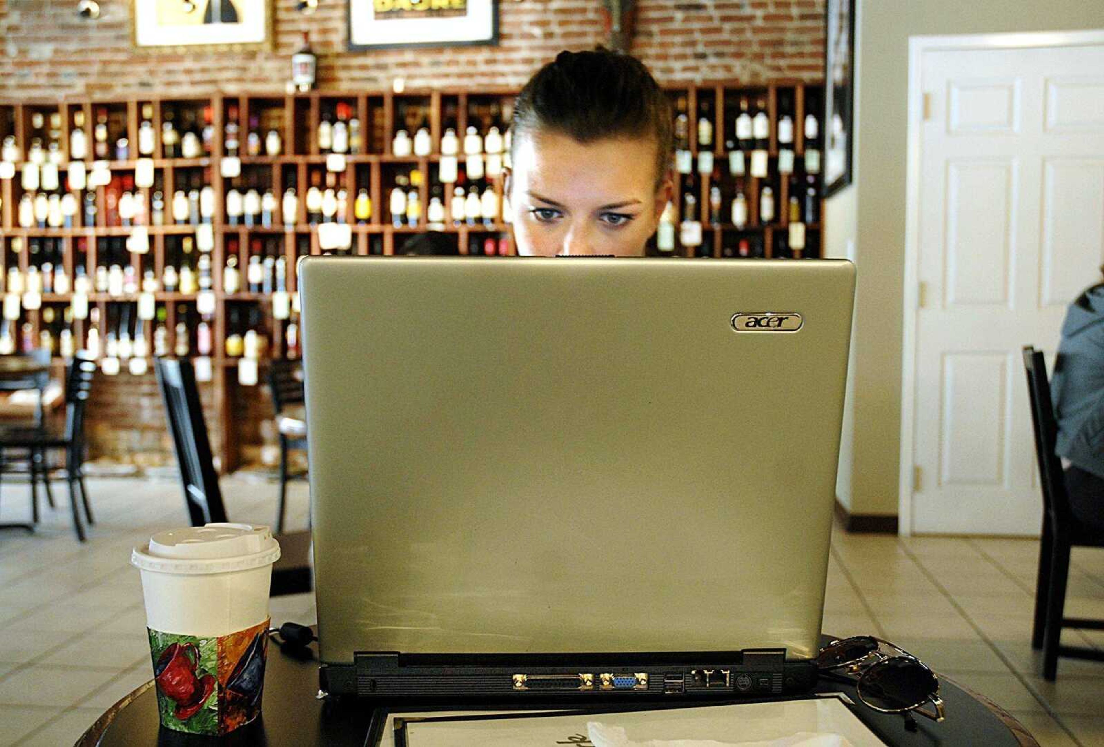 Tanja Schroot accessed the Internet with her laptop using the wireless connection at Cup 'N' Cork on Friday. Without Internet access at home, Schroot relies on public connections to check e-mail and keep in touch with friends and family. (Aaron Eisenhauer)