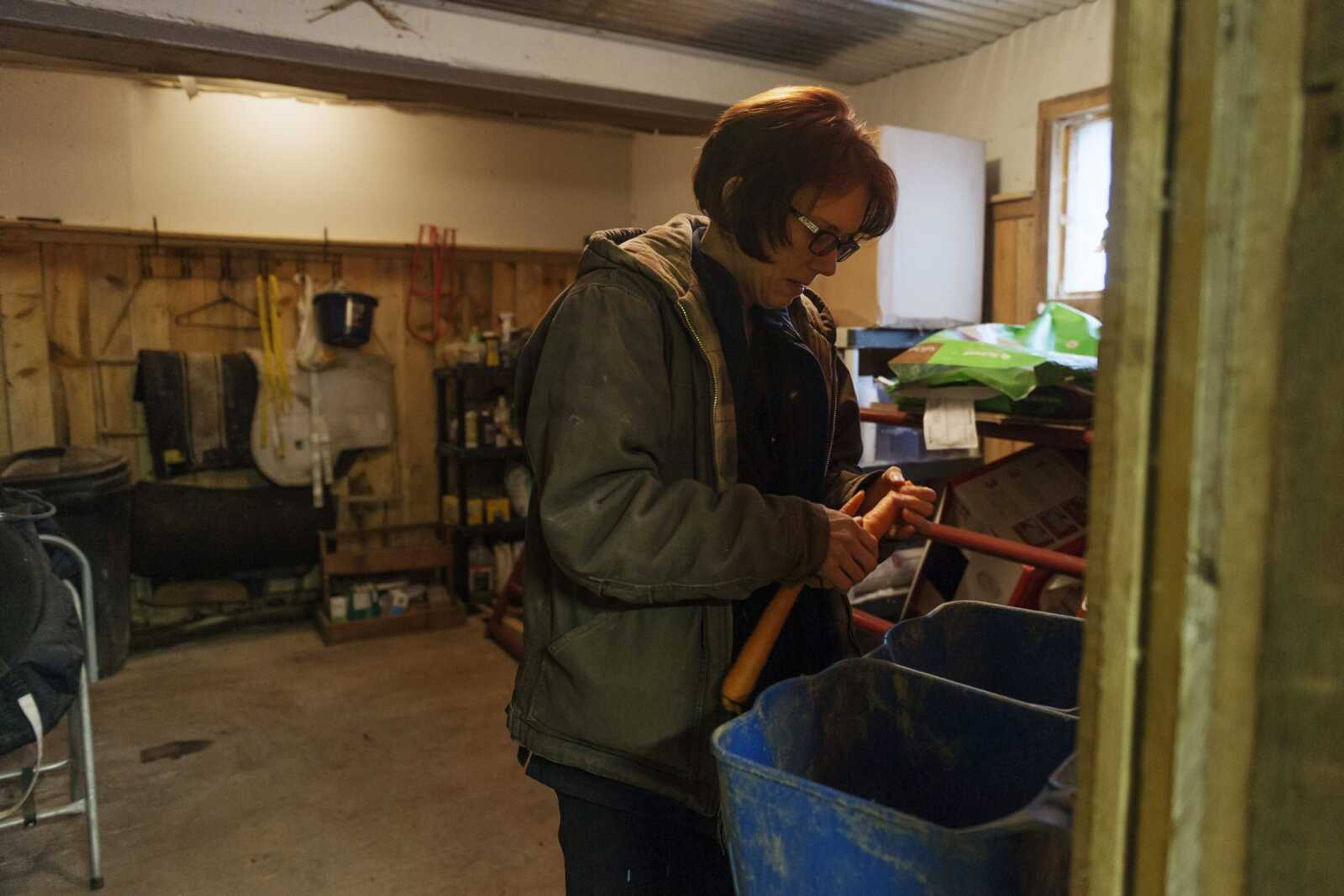 Kelly Povroznik grabs a few carrots from inside her storage space to give to her horses in their pasture outside of Clarksburg, West Virginia. Povroznik teaches an online college course hampered by slow connections on her computer and phone.