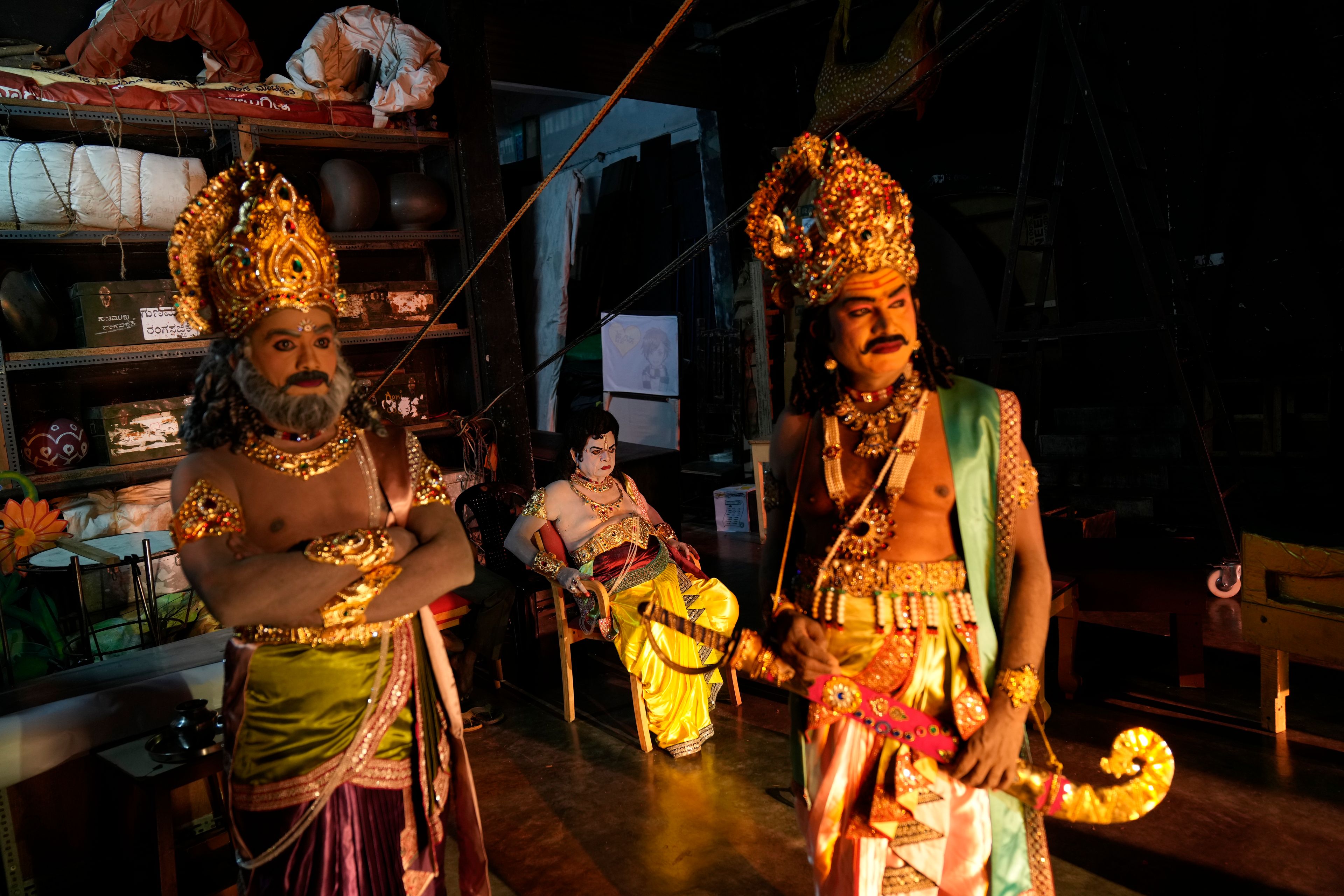 Lakshmana Dassaru, center, dressed in the character of Hindu god Rama, waits backstage with his fellow artists before their performance at a theater during Dussehra festivities, in Mysuru, India, Thursday, Oct. 10, 2024. (AP Photo/Aijaz Rahi)