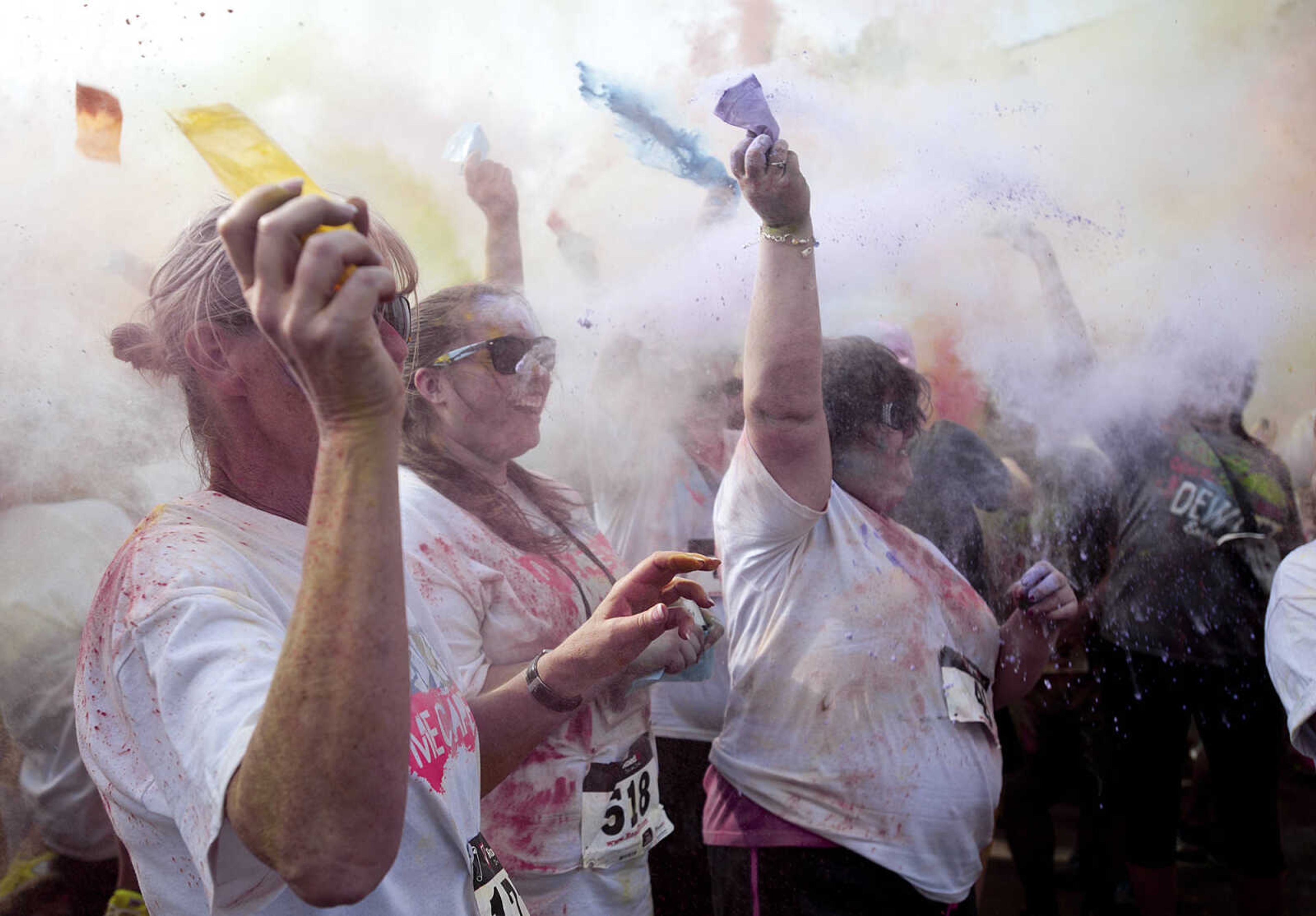 ADAM VOGLER ~ avogler@semissourian.com
Participants in the Color Me Cape 5k throw colored powder in the air in the street in front of the Bell Air Grill during the color bomb after the run Saturday, April 12, in Cape Girardeau.