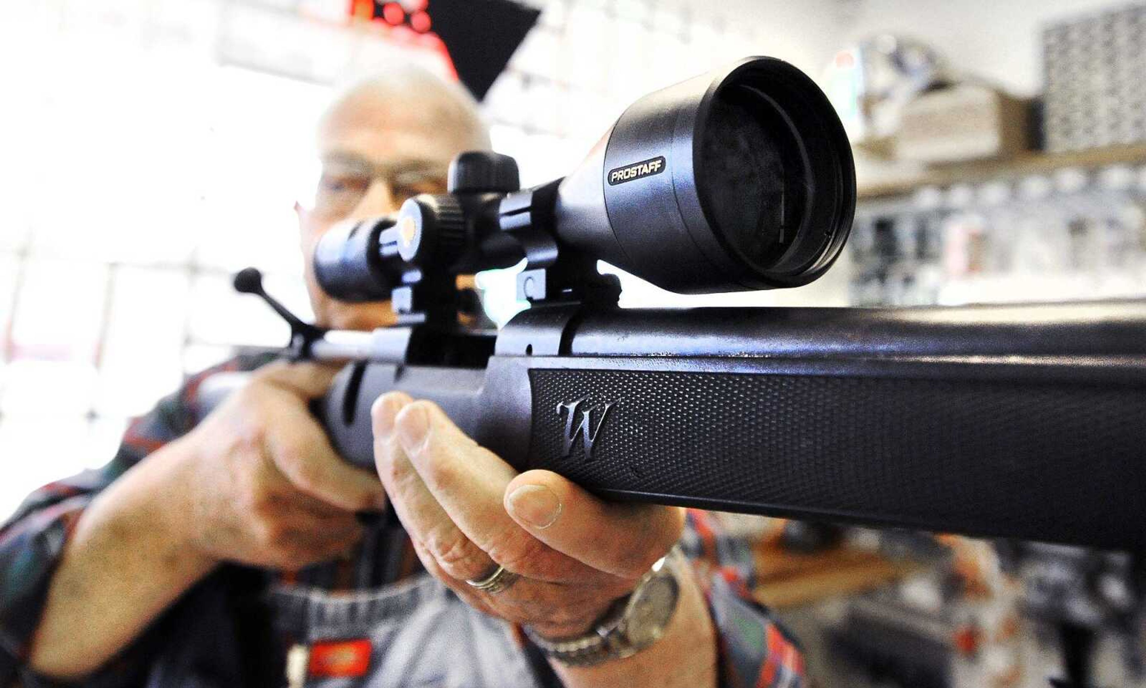 Ron Hartline checks the crosshairs of a new scope range on a customer's Winchester model 7mm Magnum on Wednesday at Shooters Gun Shop in Cape Girardeau. (Laura Simon)