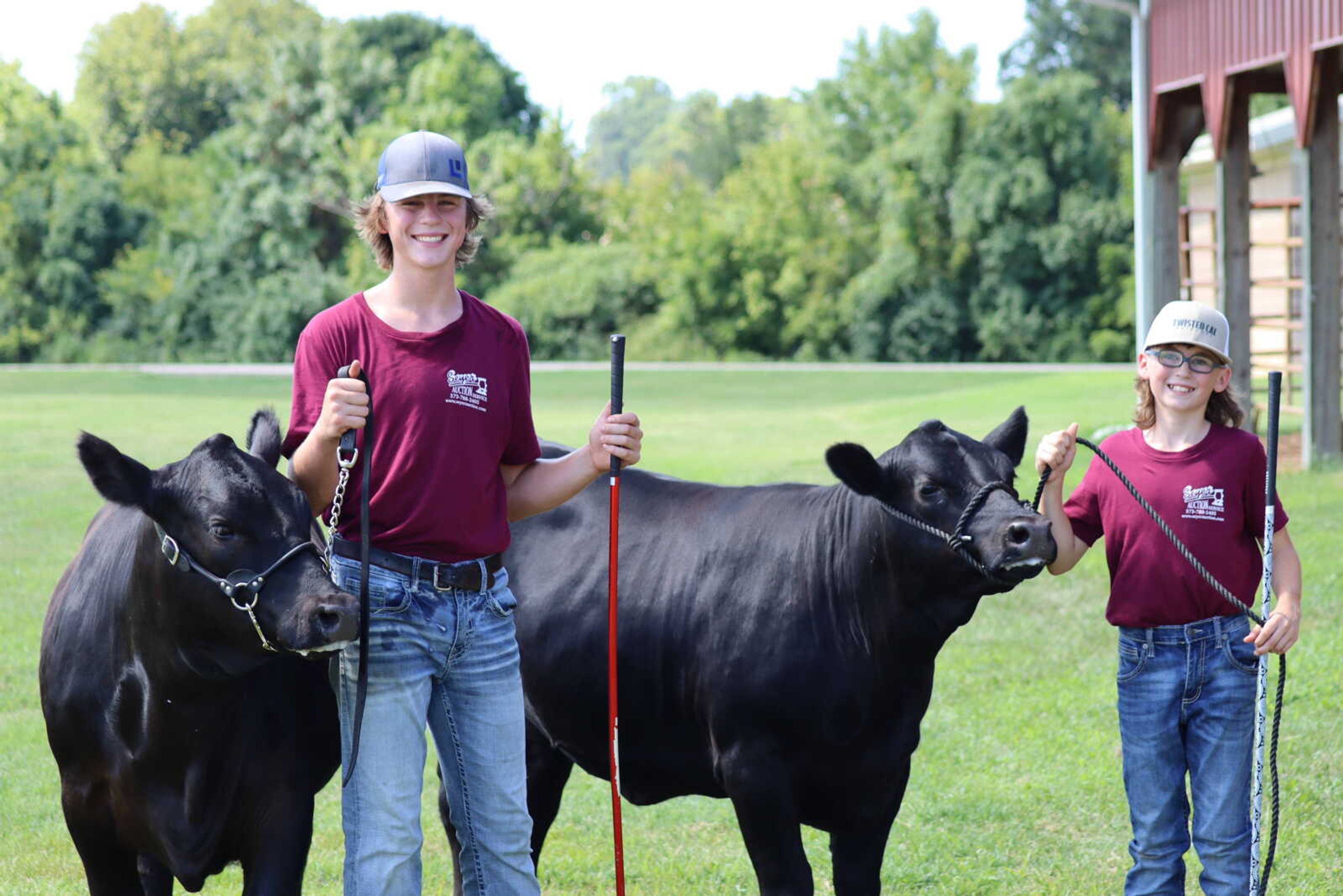 Brothers Jaden and Tristen Borgfield stand with their heifers after their cattle were judged.