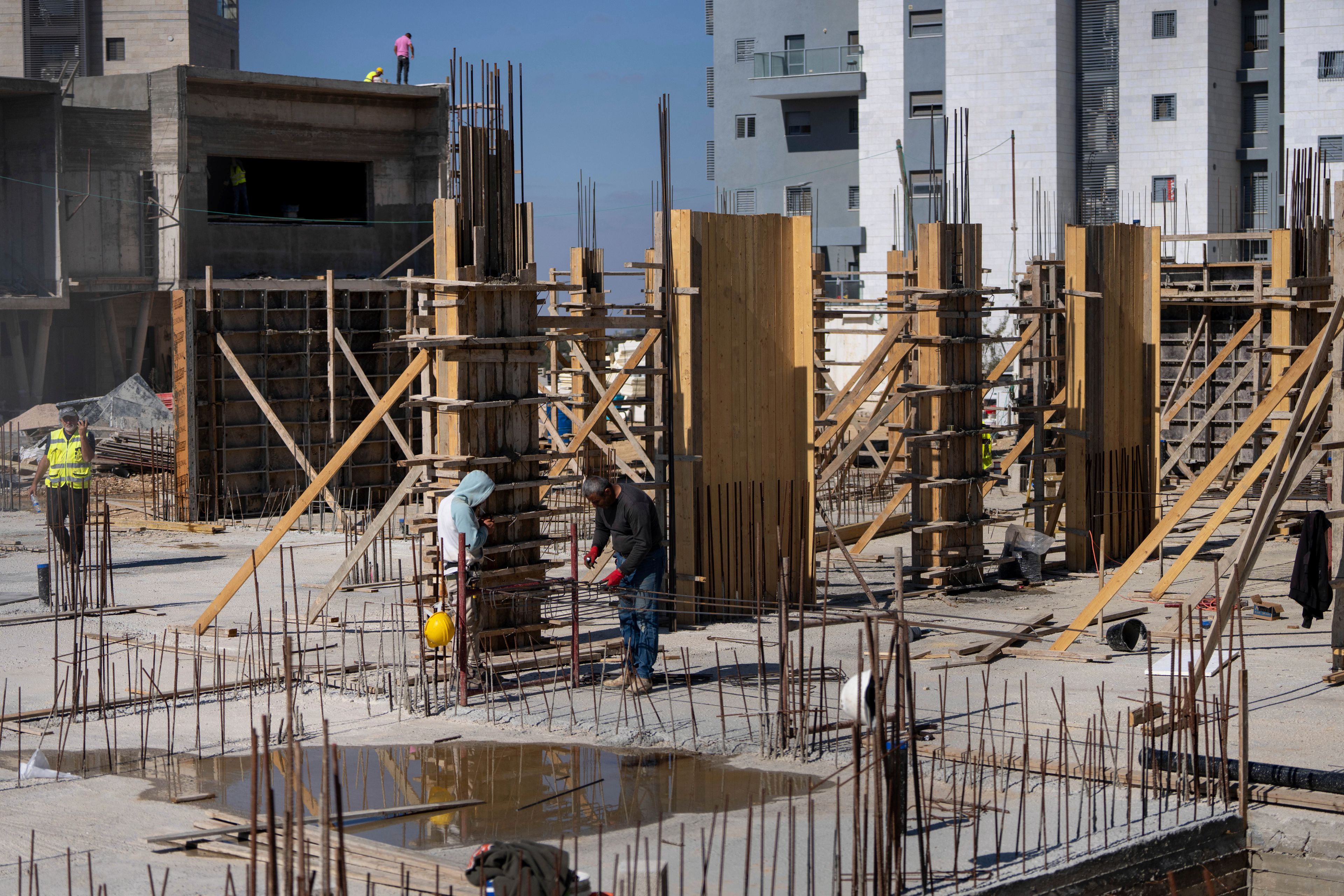 Palestinian laborers work at the site of a new housing project in the Jewish West Bank Jewish Settlement of Beit El, Monday, Nov. 11, 2024. (AP Photo/Ohad Zwigenberg)