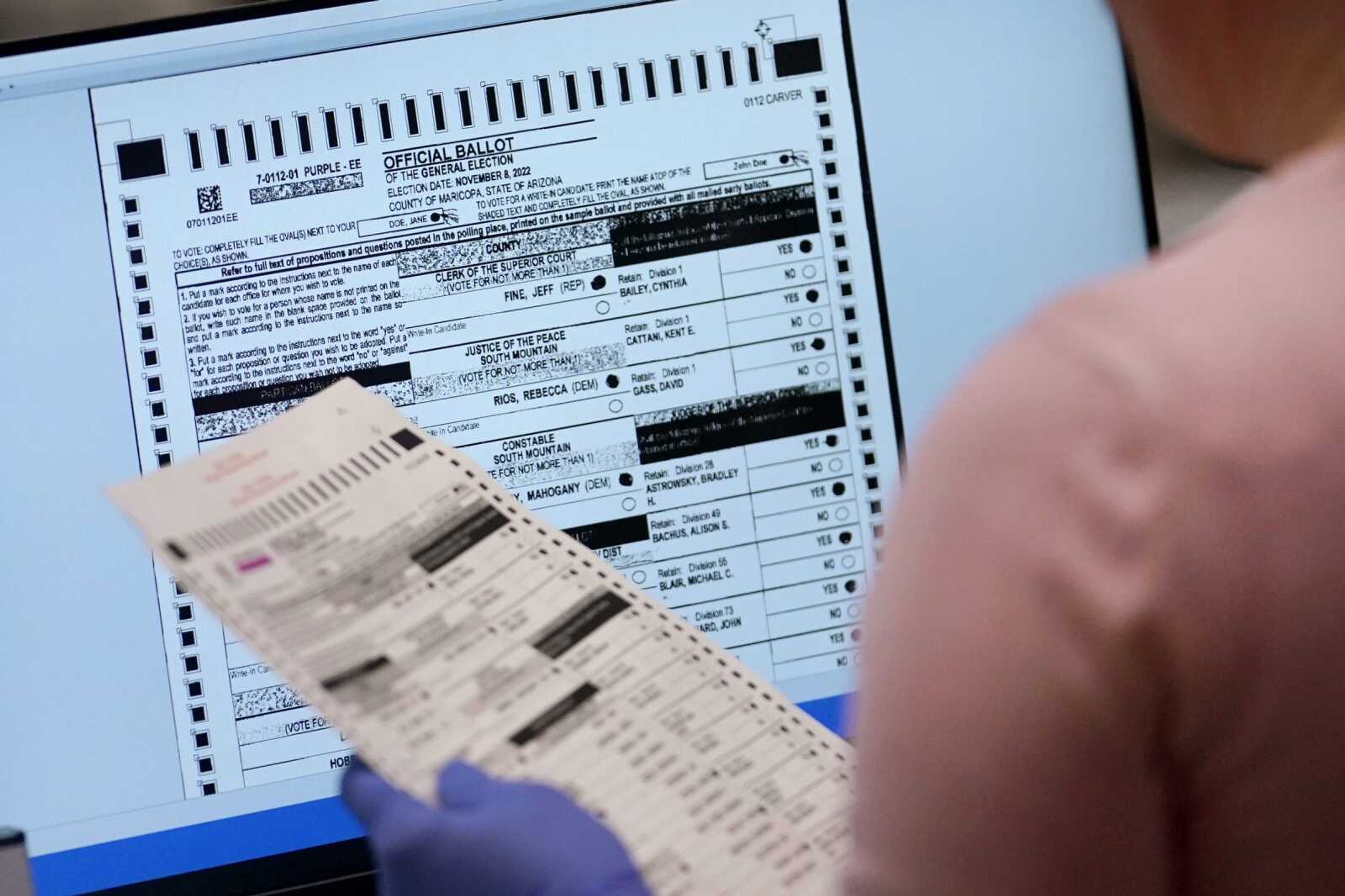 An election worker verifies a ballot on a screen inside the Maricopa County Recorders Office on Nov. 10 in Phoenix.