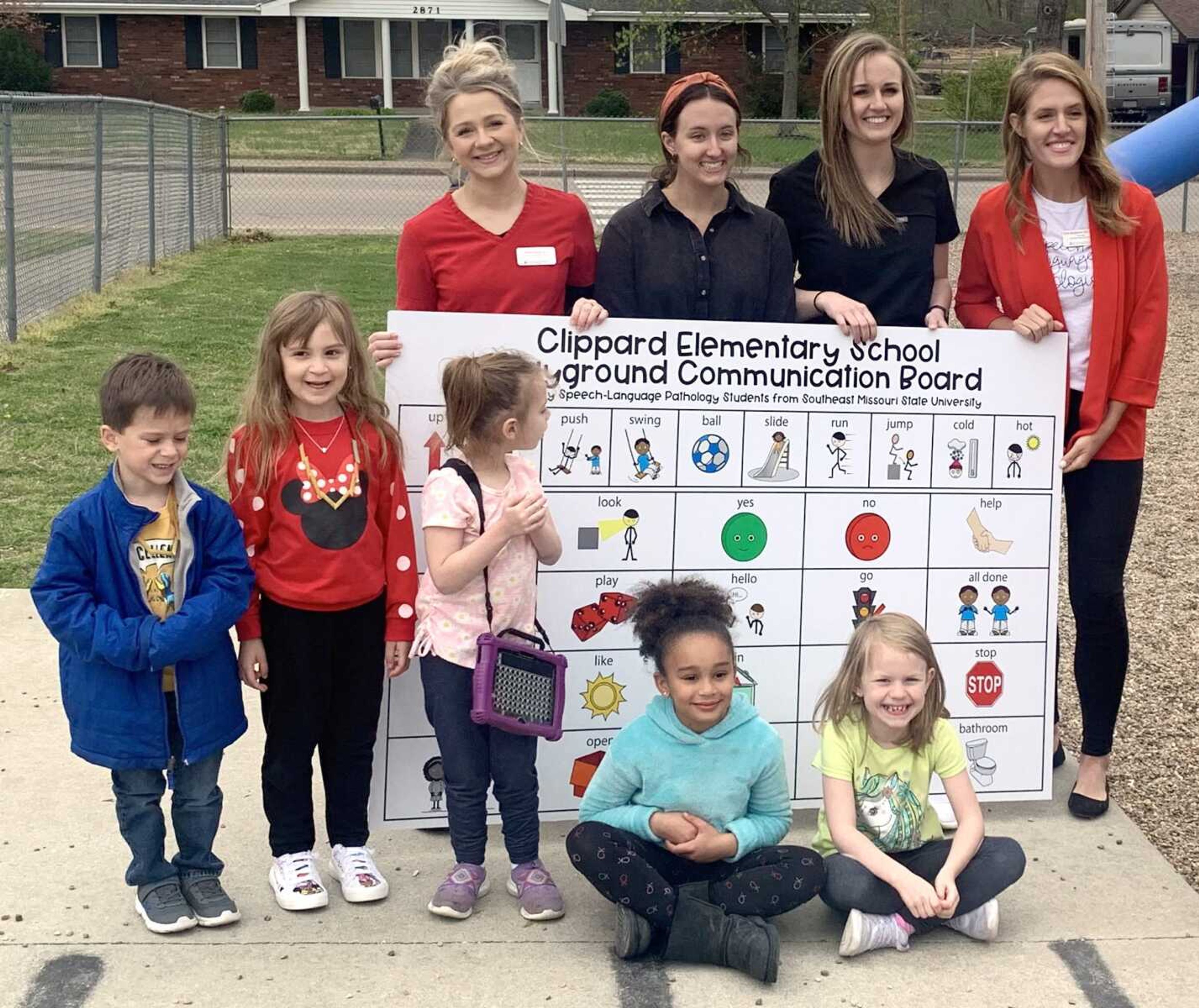 Alivia Baumann, Lexi Bergschnieder, Samantha Duffy and Emily Obergoenner of Southeast Missouri State University's Center for Speech and Hearing present a communication board to Clippard Elementary School, 2880 Hopper Road in Cape Girardeau. The communication board is one of five donated by the center and will be used to assist students with communication disorders on playgrounds.