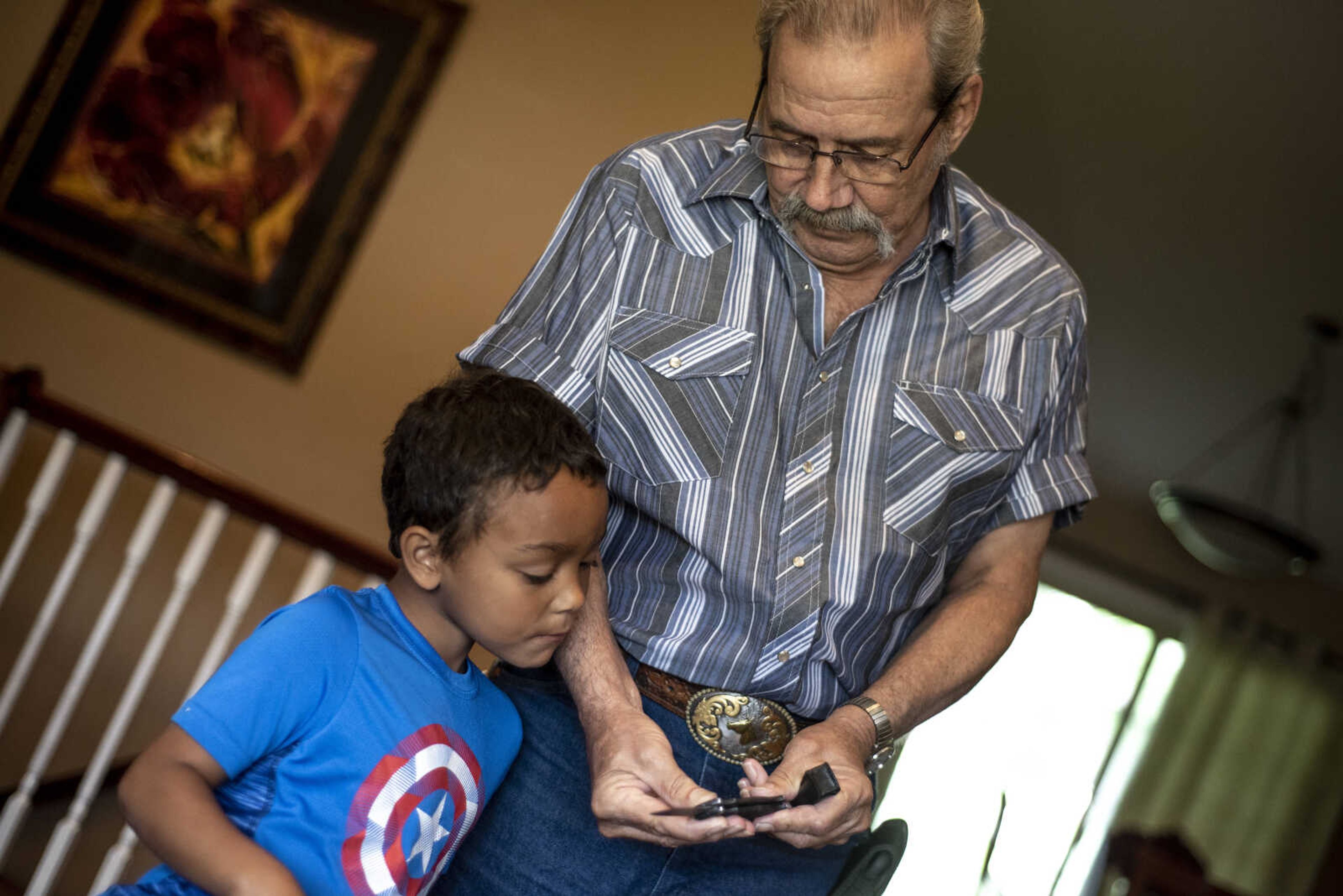 Carl Holmes shows his great-grandson Jayce Holmes, 5, how to safely close a pocket knife at their home Tuesday, June 11, 2019, in Jackson.