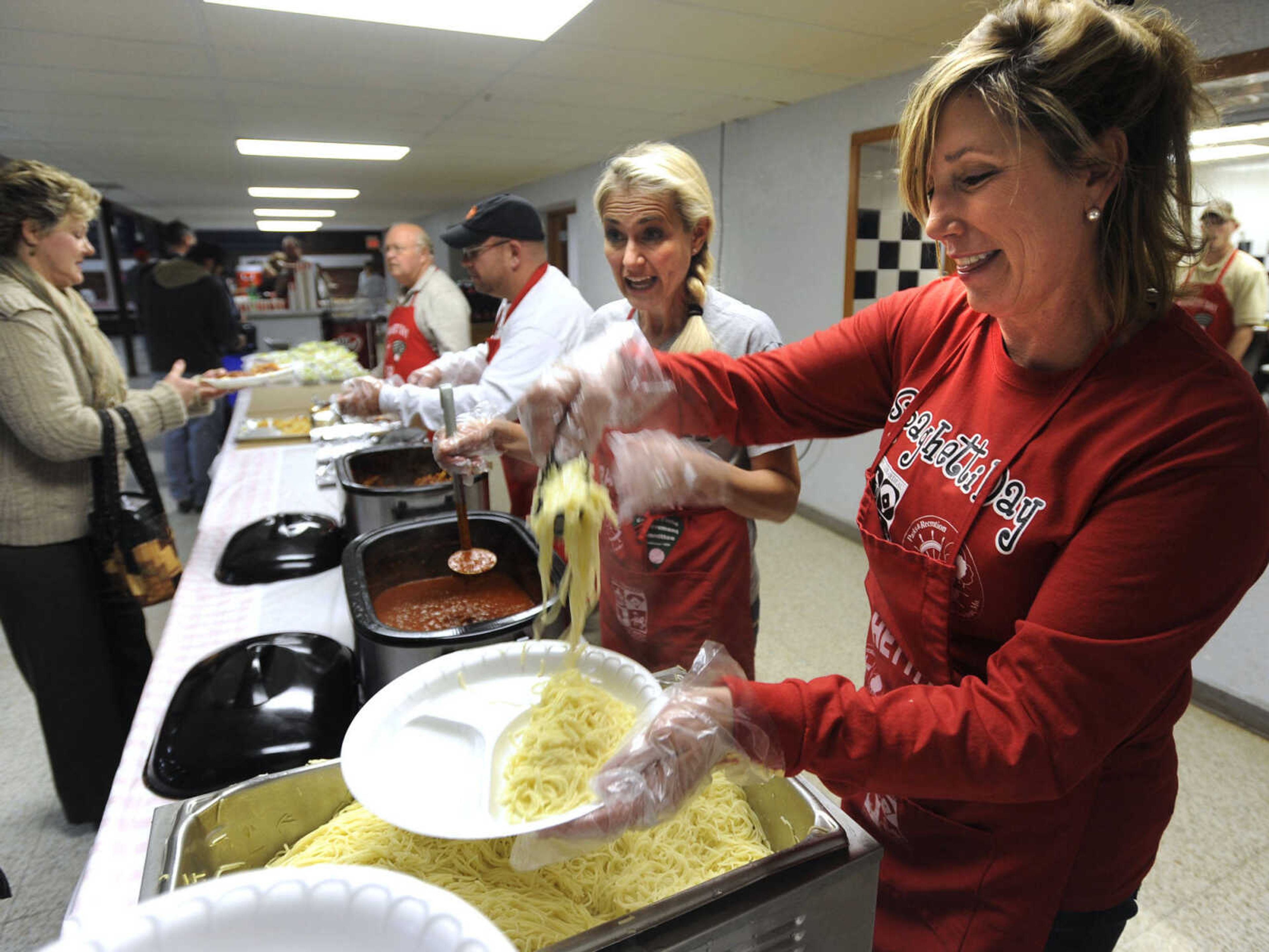 Bari Neff, right, and Lorrie Edwards serve spaghetti at the Parks & Recreation Foundation Spaghetti Day Wednesday, Nov. 13, 2013 at the Arena Building.