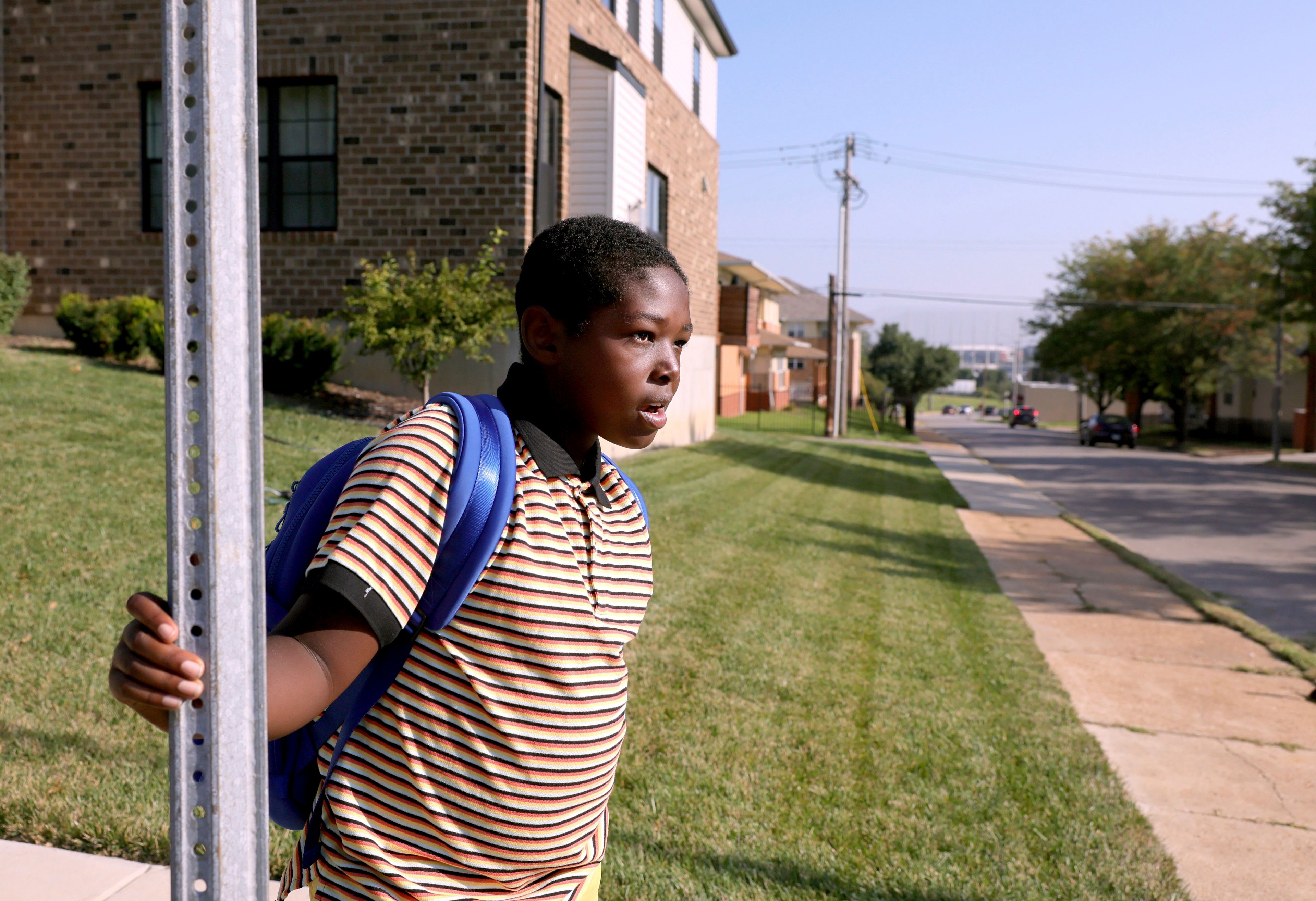 Fourth grader Shawn Baker waits for a bus to pick him up for the first day of school at Betty Wheeler Classical Junior Academy, a St. Louis Public school, on Monday, Aug. 19, 2024. (David Carson/St. Louis Post-Dispatch via AP)