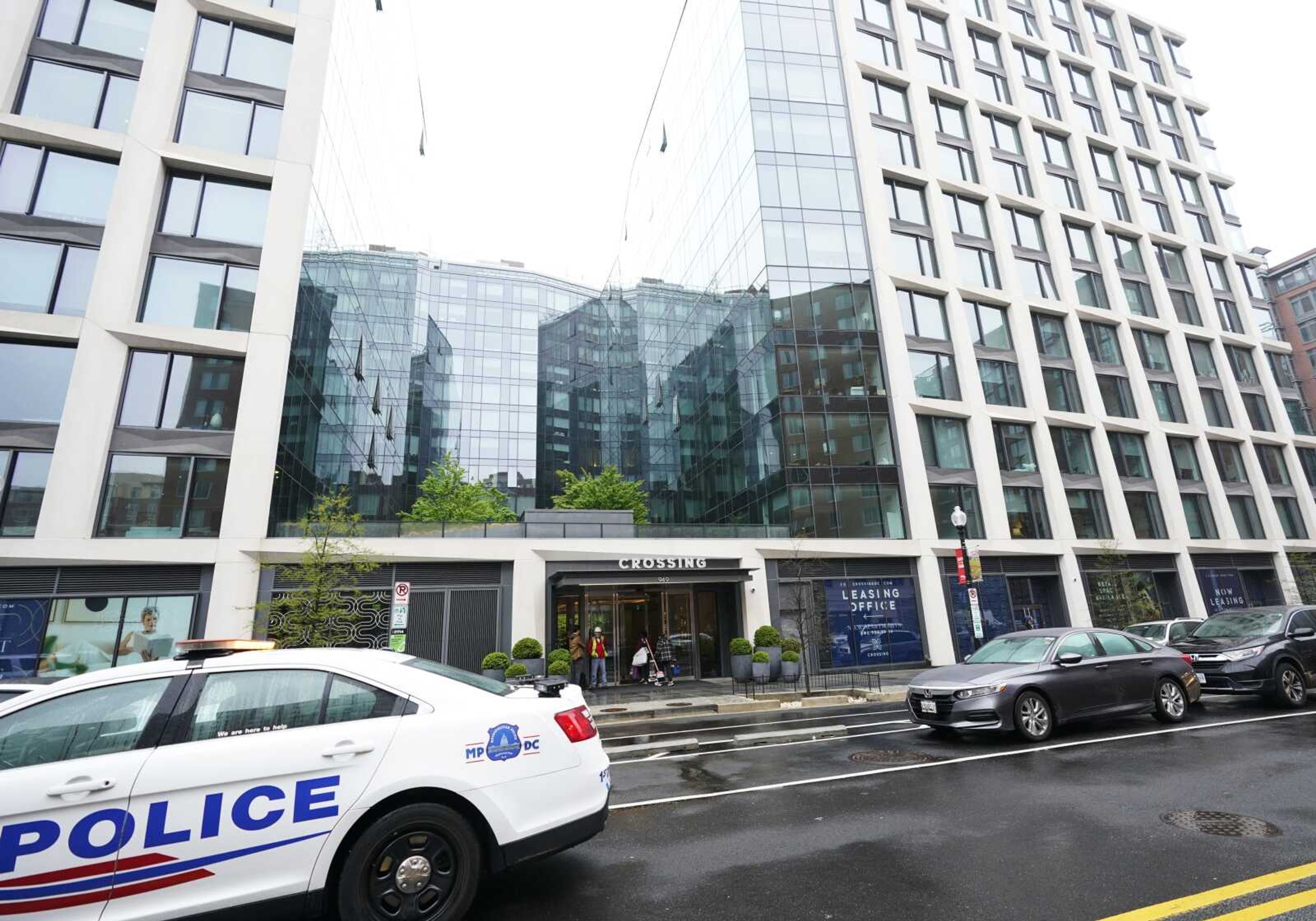 A Metropolitan Police patrol car is parked in front of a luxury apartment building Thursday in Southeast Washington.