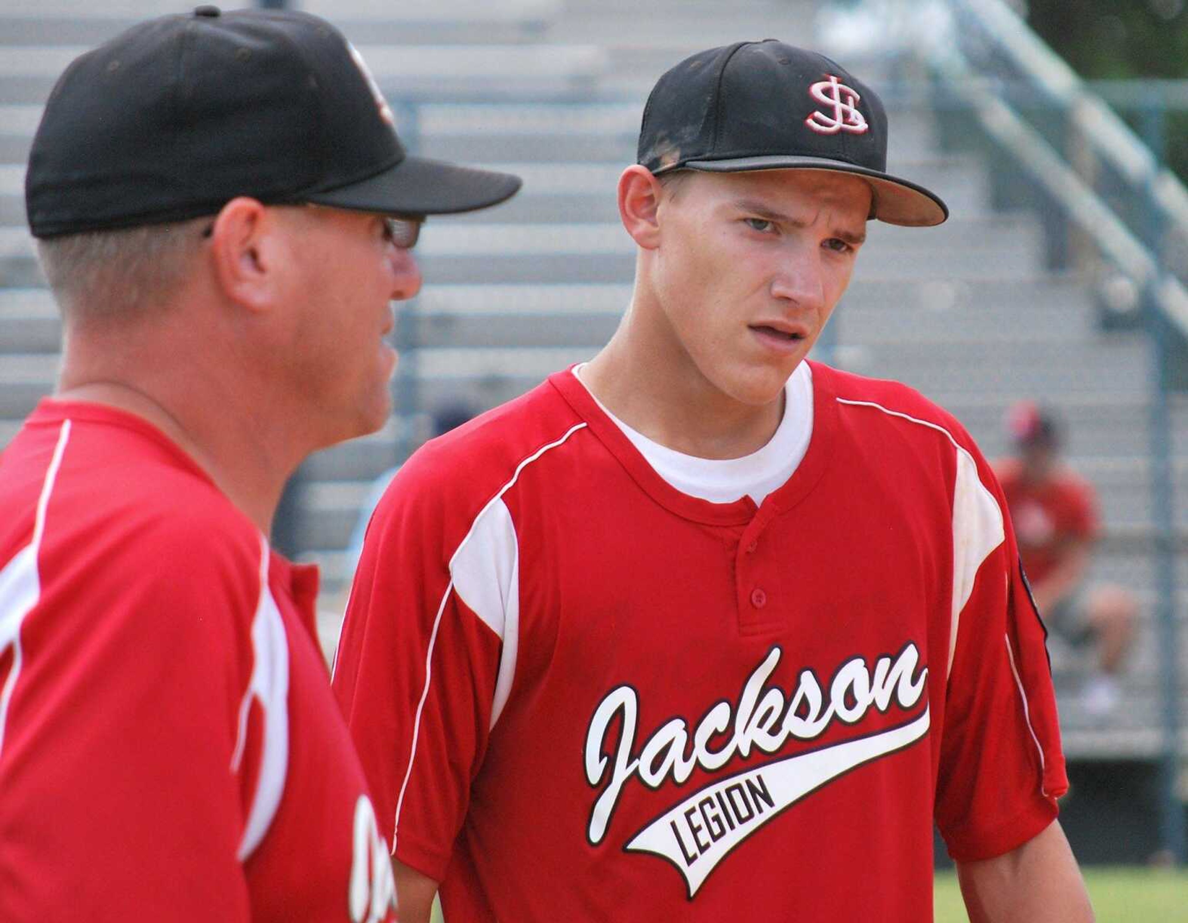 Jackson Legion Post 158 starting pitcher Gavon Turner walks off the field after pitching a complete game against Cape Girardeau Ford and Sons Post 63 in the District 14 Senior American Legion tournament Saturday, July 18, 2015, in Sikeston. Jackson coach Mark Lewis is pictured left. (Trent Singer)