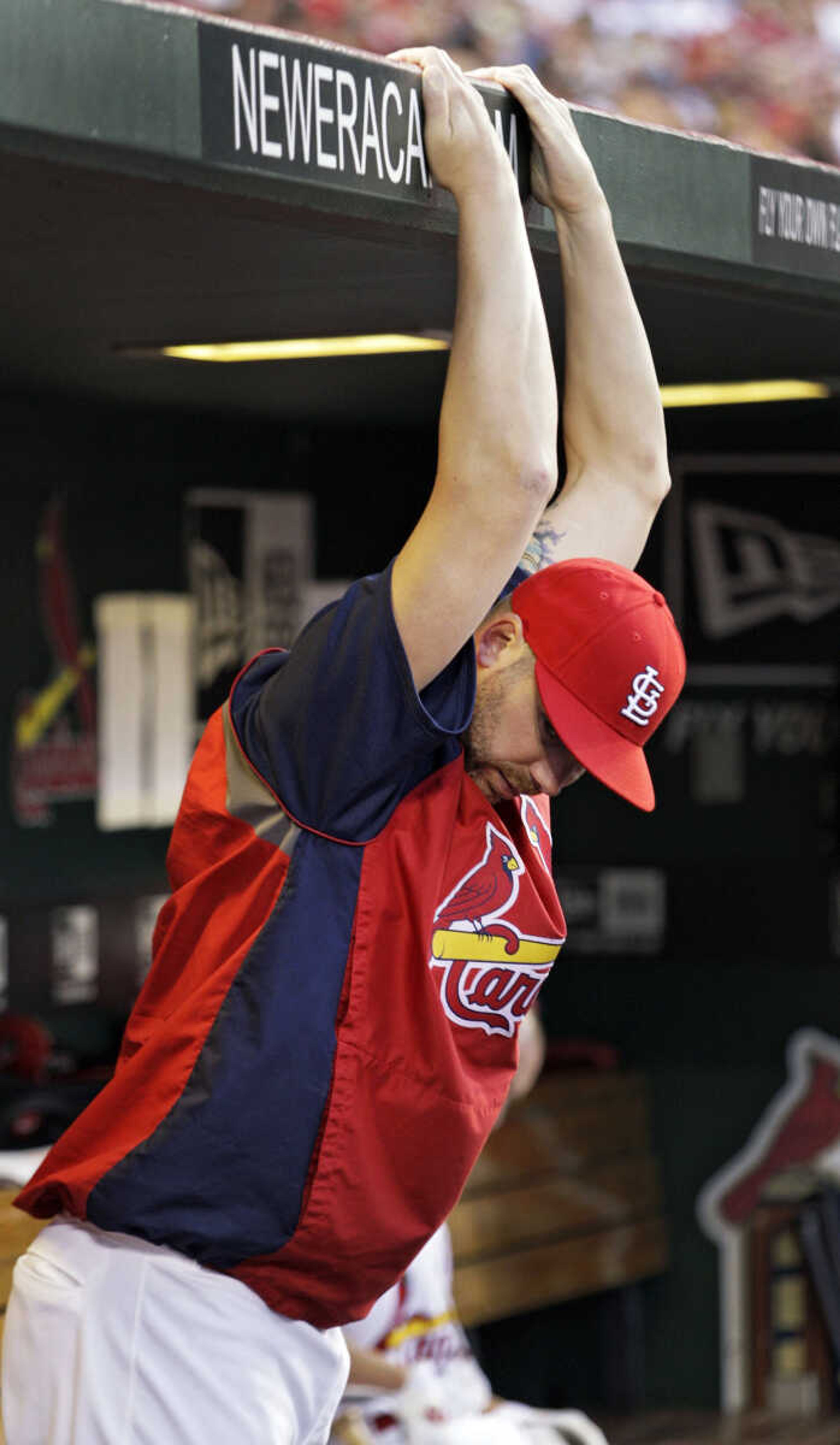 FILE - In this June 12, 2012, file photo, injured St. Louis Cardinals pitcher Chris Carpenter stretches in the dugout in the fourth inning of a baseball game against the Chicago White Sox in St. Louis. Carpenter will undergo season-ending surgery to repair a nerve issue in his shoulder that has sidelined him since spring training and will need three to six months recovery time, according to general manager John Mozeliak, Tuesday, July 3. (AP Photo/Tom Gannam, File)