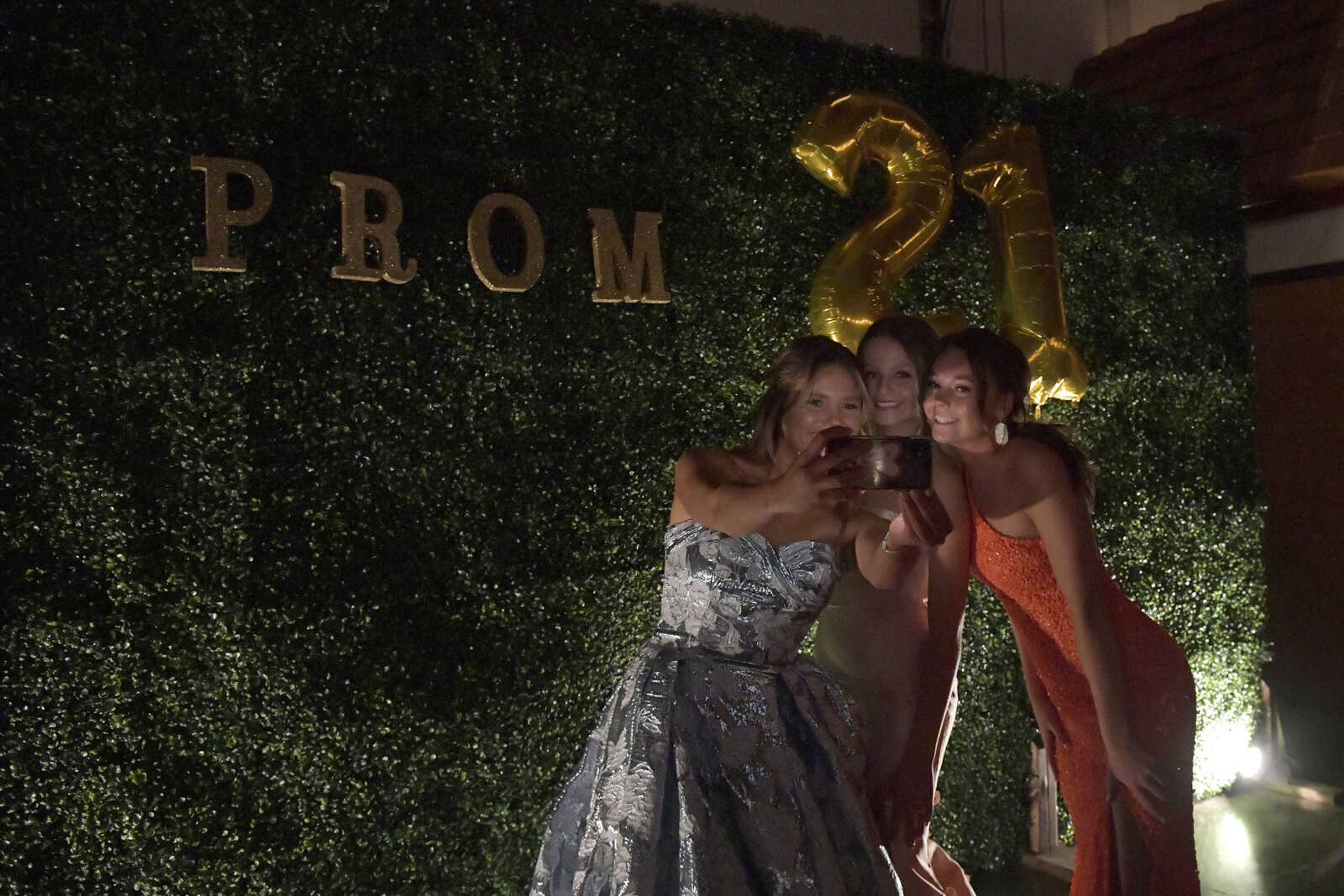 Sophie Ohmes, Julia Mirgaux and Grace Sanders, from left to right, take a selfie during Notre Dame's prom at Bavarian Halle in Jackson on Friday, April 30, 2021.