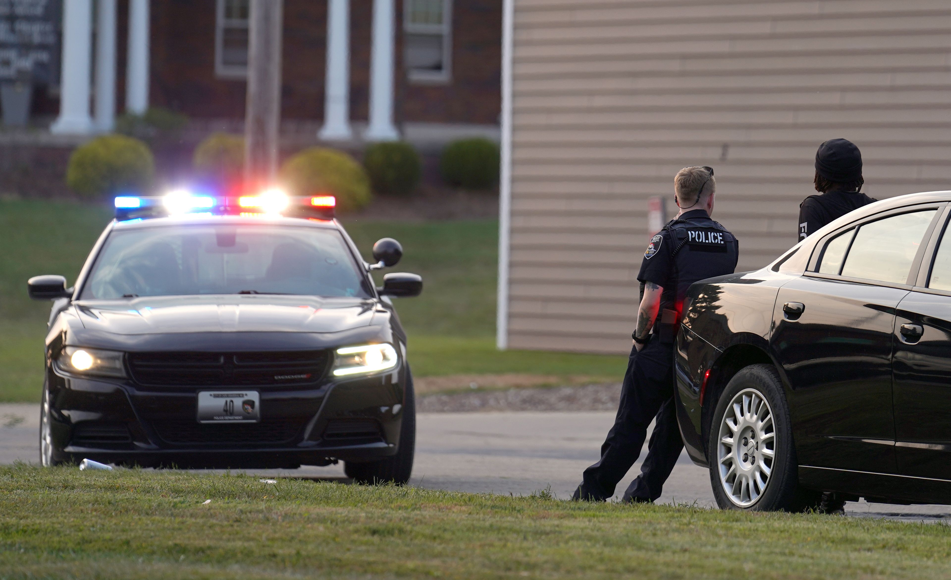 A Cape Girardeau police officer, left, speaks with a witness after a shooting Wednesday, Sept. 11, near the entrance to Village on the Green apartment complex on North Sprigg Street in Cape Girardeau. A of Wednesday night, a suspect had not been apprehended. According to an alert sent to Southeast Missouri State University students Wednesday night, police are looking for a white Dodge Charger in connection with the case. Anyone with information may contact the Cape Girardeau Police Department at (573) 335-6621.