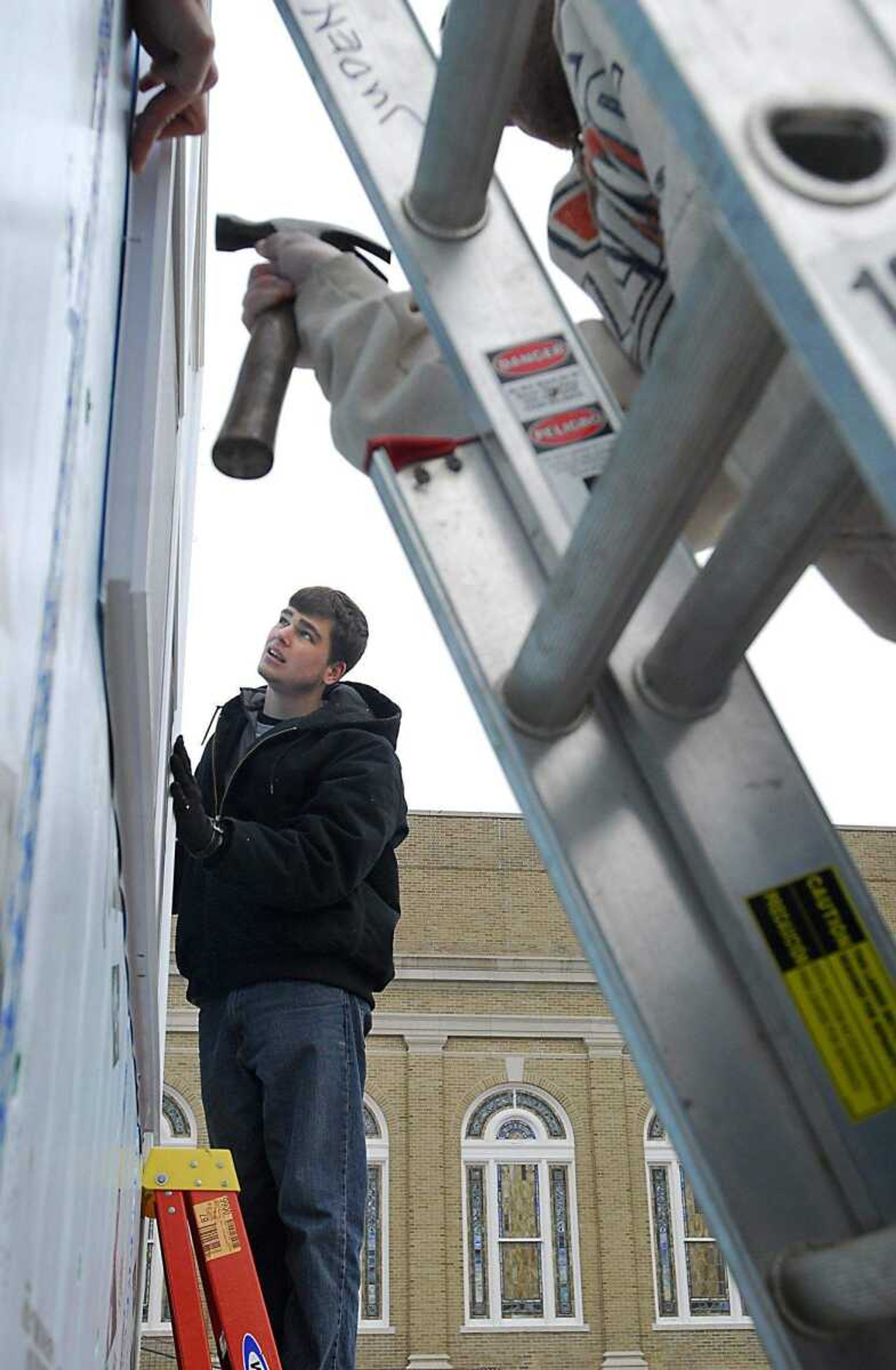 KIT DOYLE ~ kdoyle@semissourian.com
Volunteer Andrew Valleroy, 22, supports a window as it is installed Thursday, March 12, 2009, in the Habitat for Humanity home being built in the Alumni Center parking lot in Cape Girardeau.