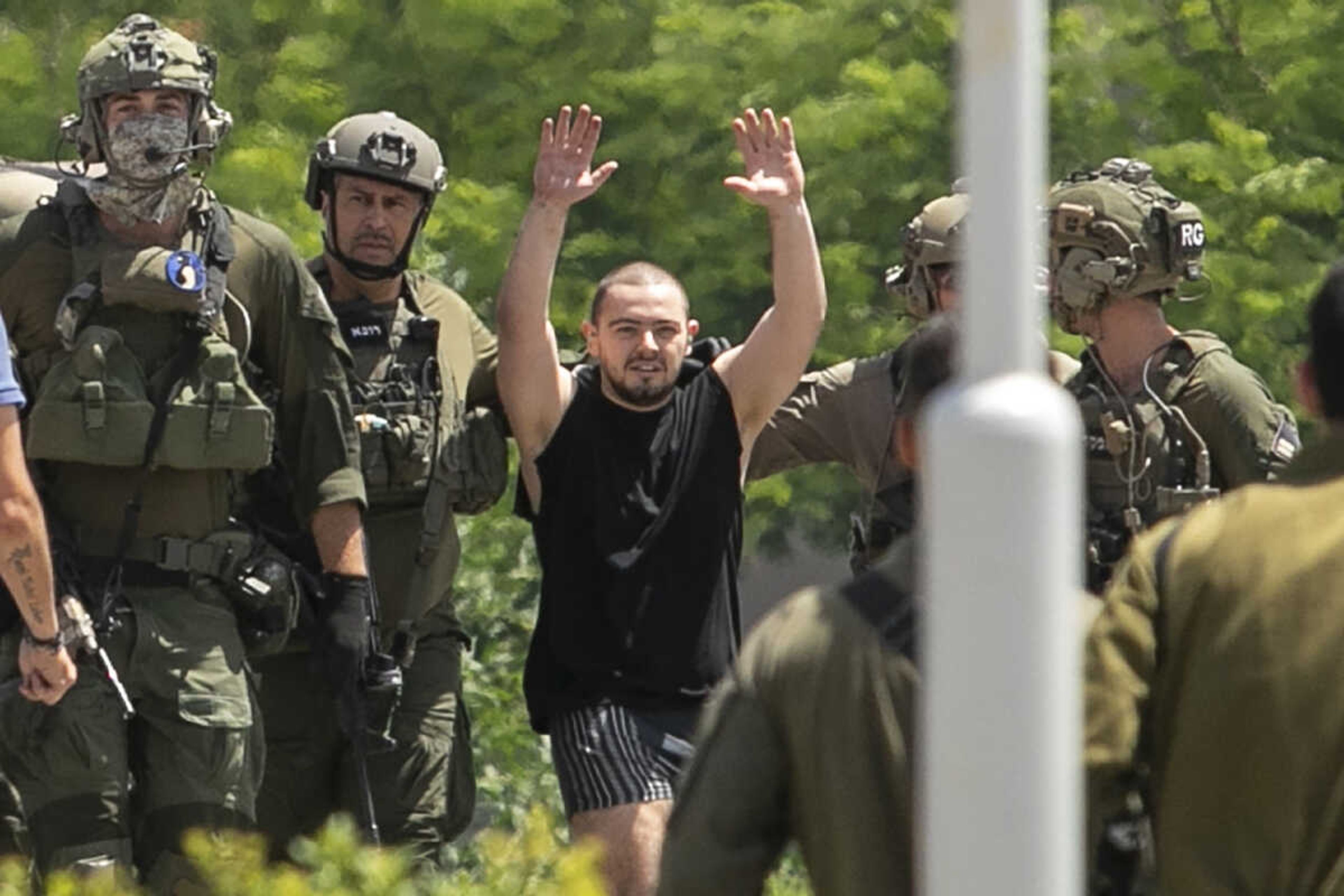 Almog Meir Jan, 21, kidnapped from Israel in a Hamas-led attack Oct. 7, raises his hands after arriving by helicopter to the Sheba Medical Center on Saturday in Ramat Gan, Israel. Israel rescued four hostages in Gaza who were kidnapped in a Hamas-led attack.