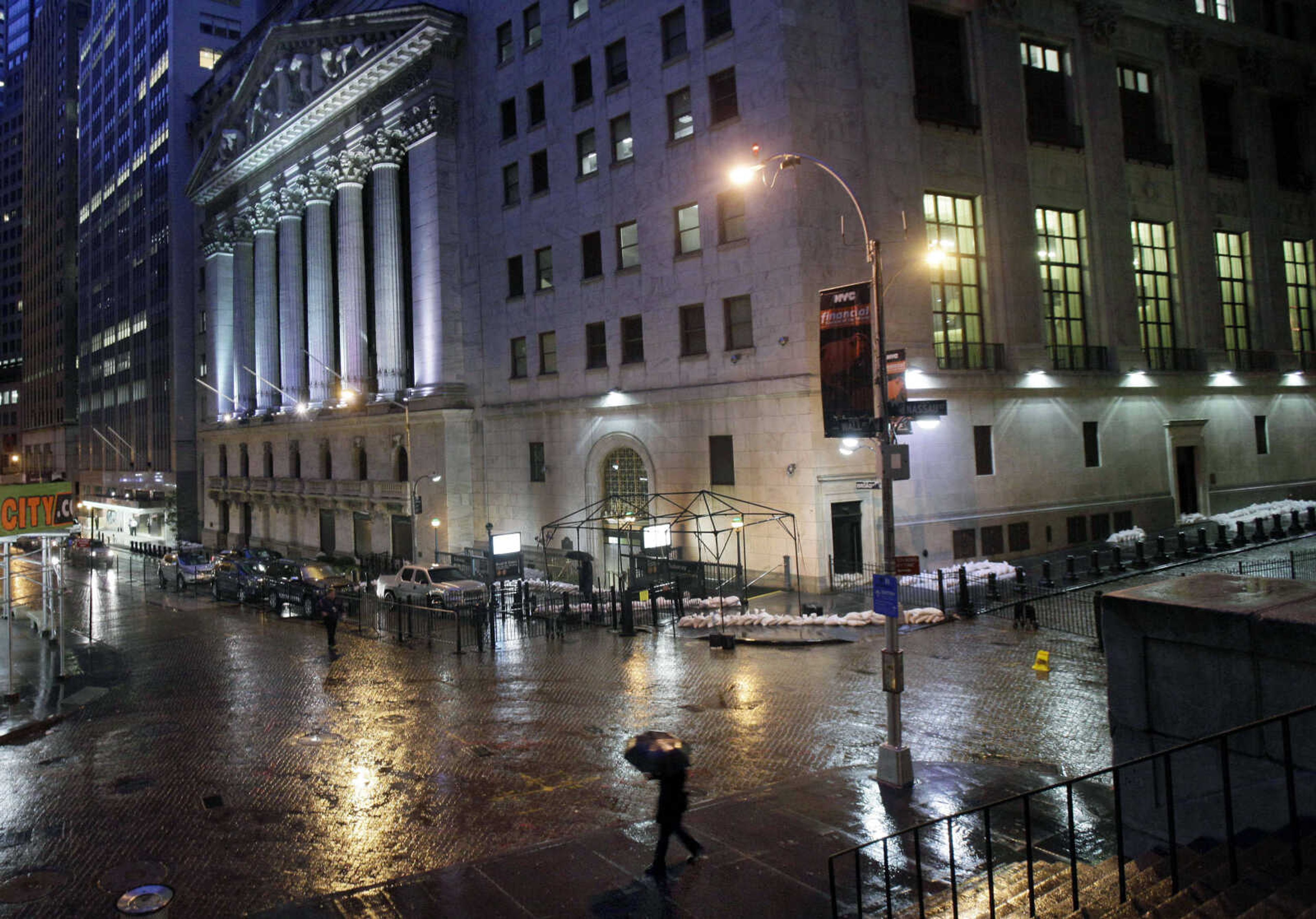 Sand bags protect the front of the New York Stock Exchange, Monday, Oct. 29, 2012. Hurricane Sandy continued on its path Monday, forcing the shutdown of mass transit, schools and financial markets, sending coastal residents fleeing, and threatening a dangerous mix of high winds and soaking rain. There had been plans to allow electronic trading to go forward on the New York Stock Exchange but with a storm surge expected to cover parts of lower Manhattan in water, officials decided late Sunday that it was too risky to ask any personnel to staff the exchanges. (AP Photo/Richard Drew)