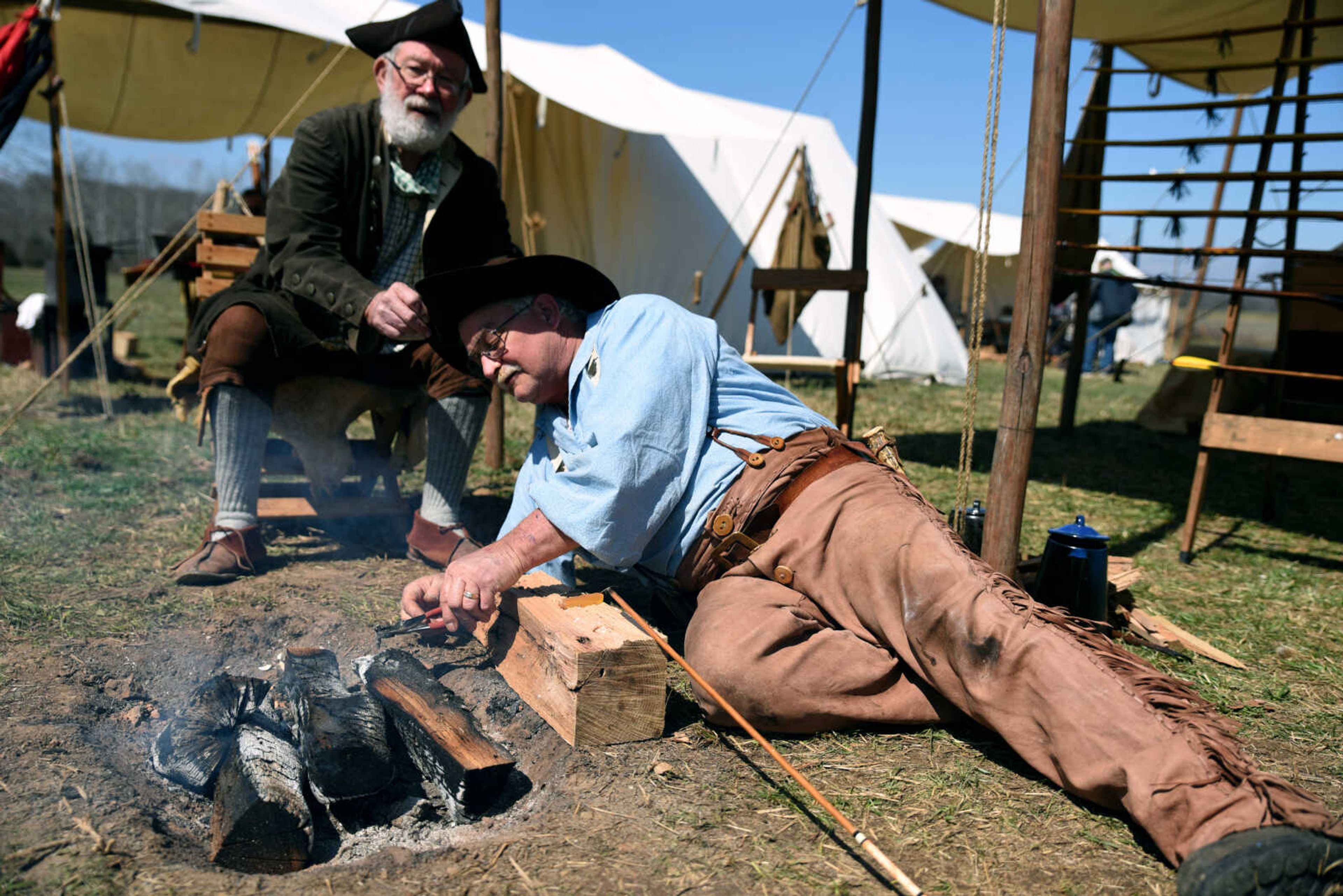 Bill Burgess, back, lifts David McCutcheon's hat as he tips an arrow at the second annual Eastern Ozark Rendezvous held at Bark's Planation Saturday, March 17, 2018, in Glenallen.