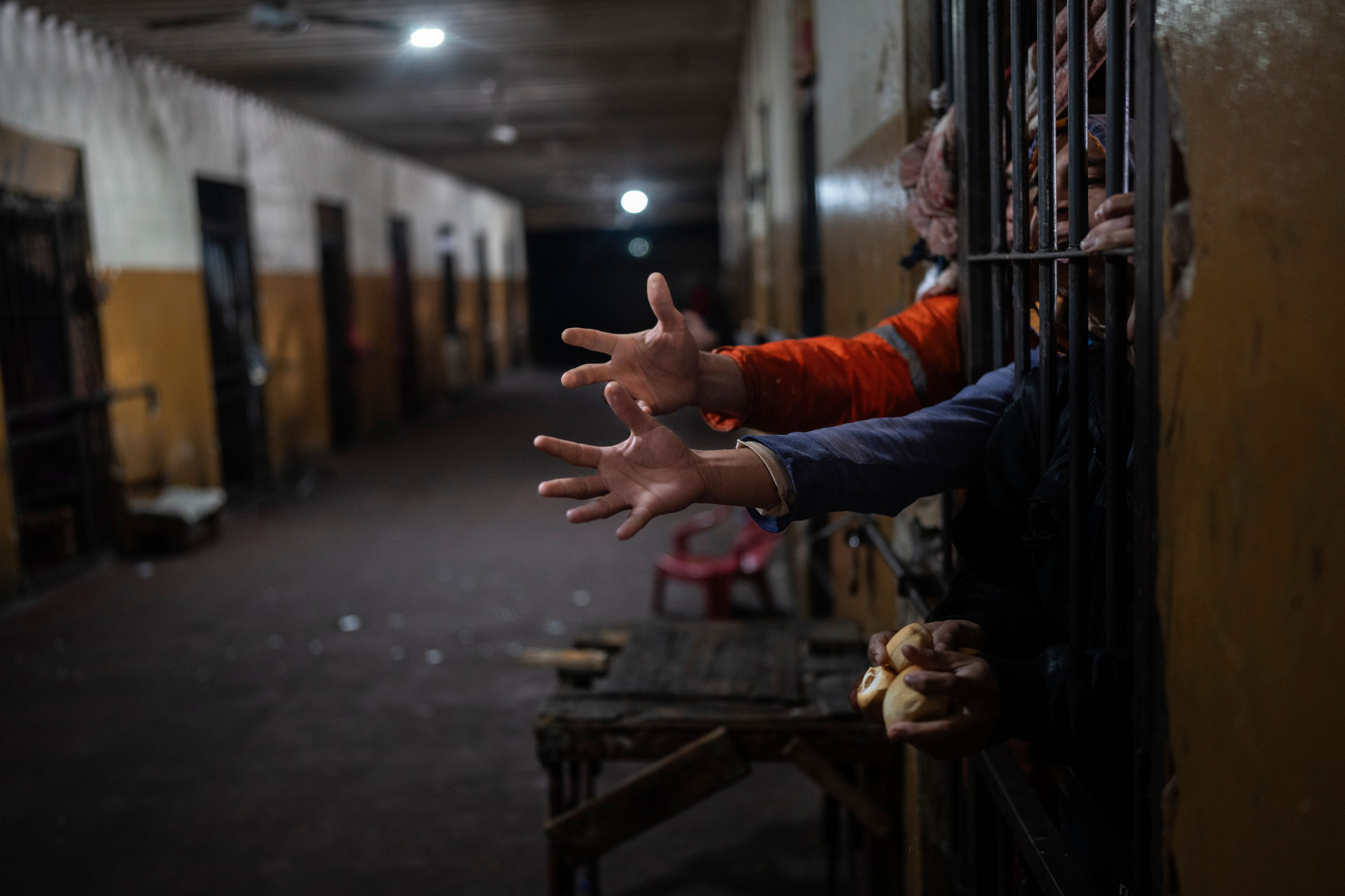 Prisoners reach out from their cell for bread at lunchtime at the Juan de la Vega prison in Emboscada, Paraguay, Friday, July 12, 2024. (AP Photo/Rodrigo Abd)