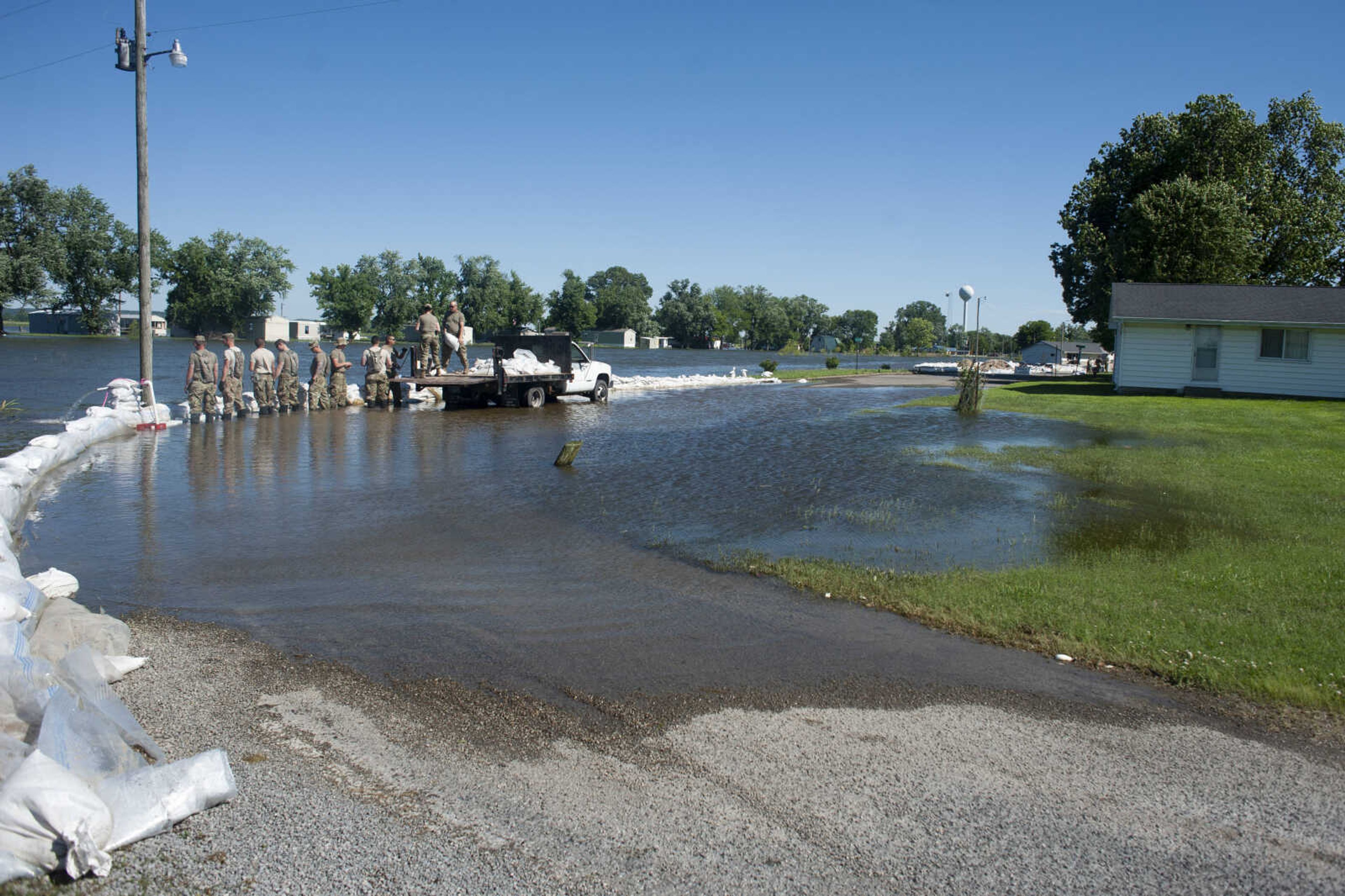 Members of the Illinois National Guard build up existing sandbag barriers to hold back floodwaters Monday, June 10, 2019, along Brookwood Drive in East Cape Girardeau, Illinois.