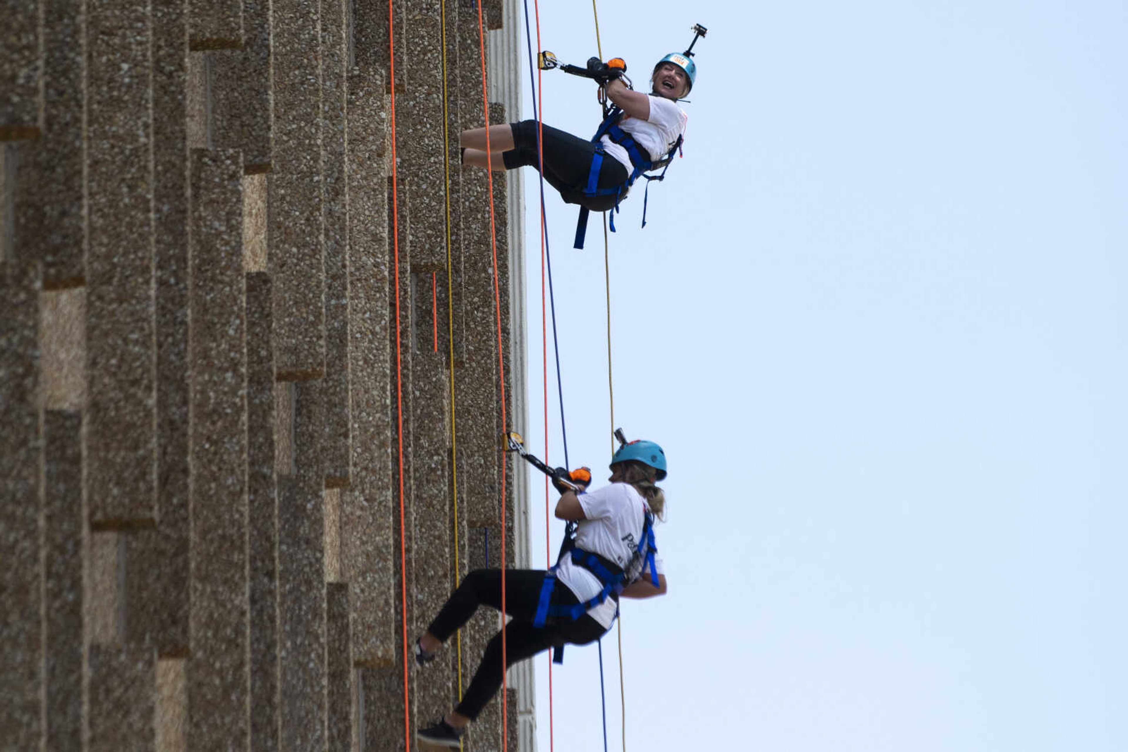 Elizabeth Shelton, executive director of United Way of Southeast Missouri, top, laughs while rappelling down the side of Southeast Missouri State University's Towers South dormitory with Raechel Reinitz, community relations manager for the United Way of Southeast Missouri, during the United Way of Southeast Missouri's Over the Edge fundraising event Friday, May 17, 2019, in Cape Girardeau.&nbsp;