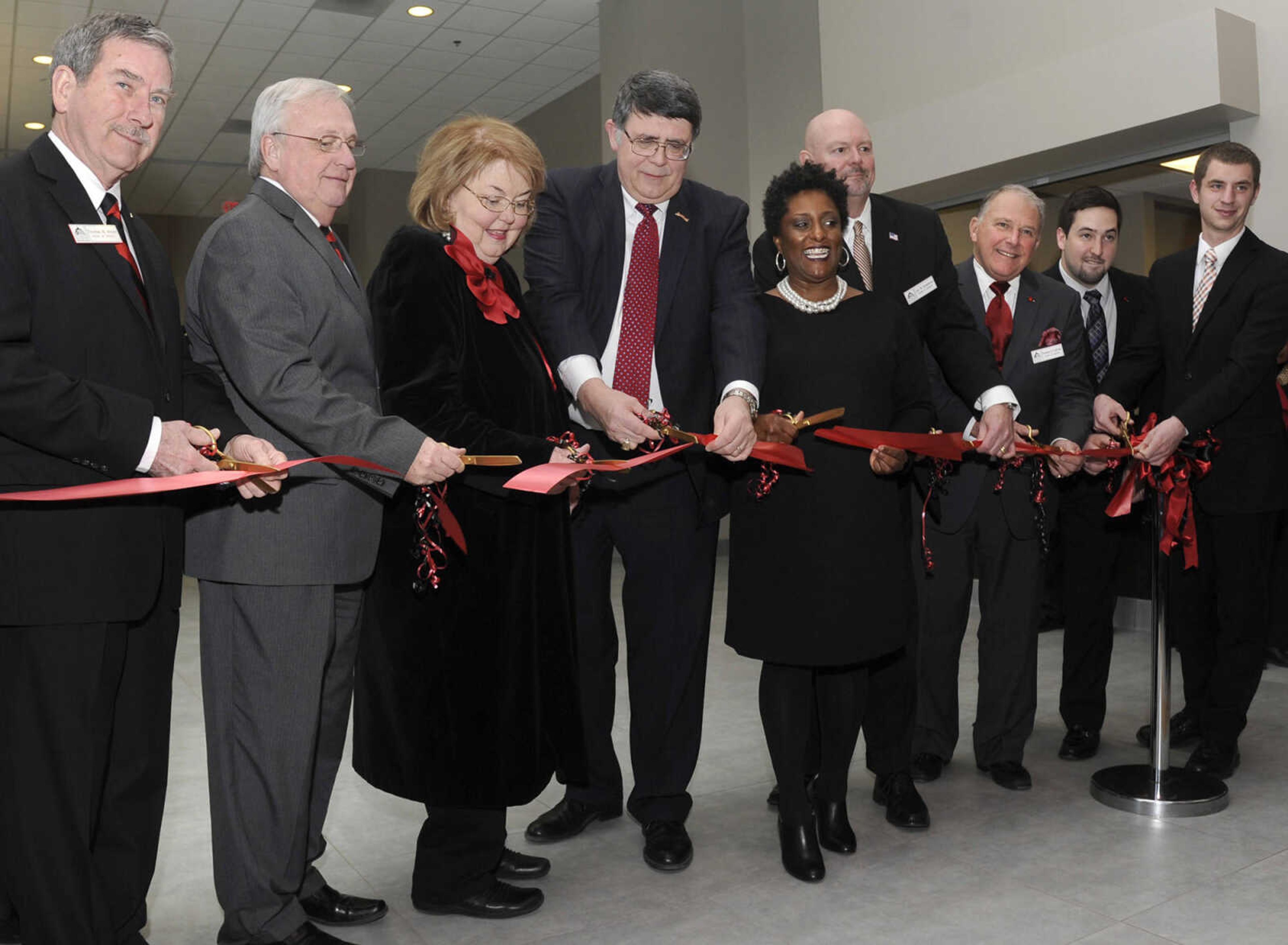 Dr. Kenneth W. Dobbins and his wife, Jeanine Larson Dobbins, cut a ceremonial ribbon Friday, Feb. 27, 2015 after a dedication ceremony for the Kenneth & Jeanine Dobbins River Campus Center. From left are regent Thomas M. Meyer, Board of Regents president Doyle Privett, Jeanine and Kenneth Dobbins, Board of Regents vice-president Kendra Neely-Martin, regent Jay B. Knudtson, regent Donald G. LaFerla, student representative Austin Cordell and Student Government president Caleb Cockrill. (Fred Lynch)