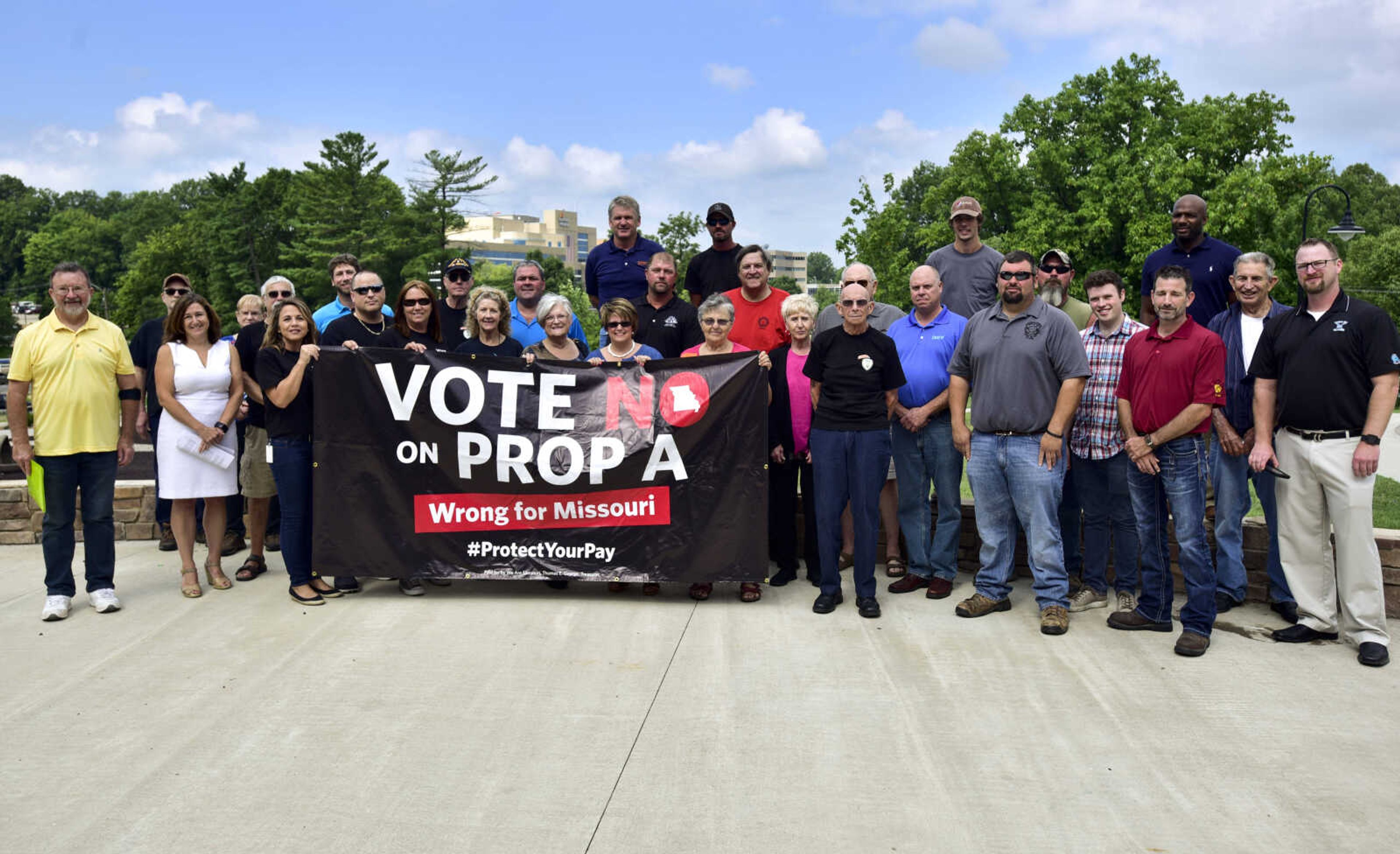 Opponents of Proposition A pose for a photo Monday, July 23, 2018, before a rally at Capaha Park in Cape Girardeau.