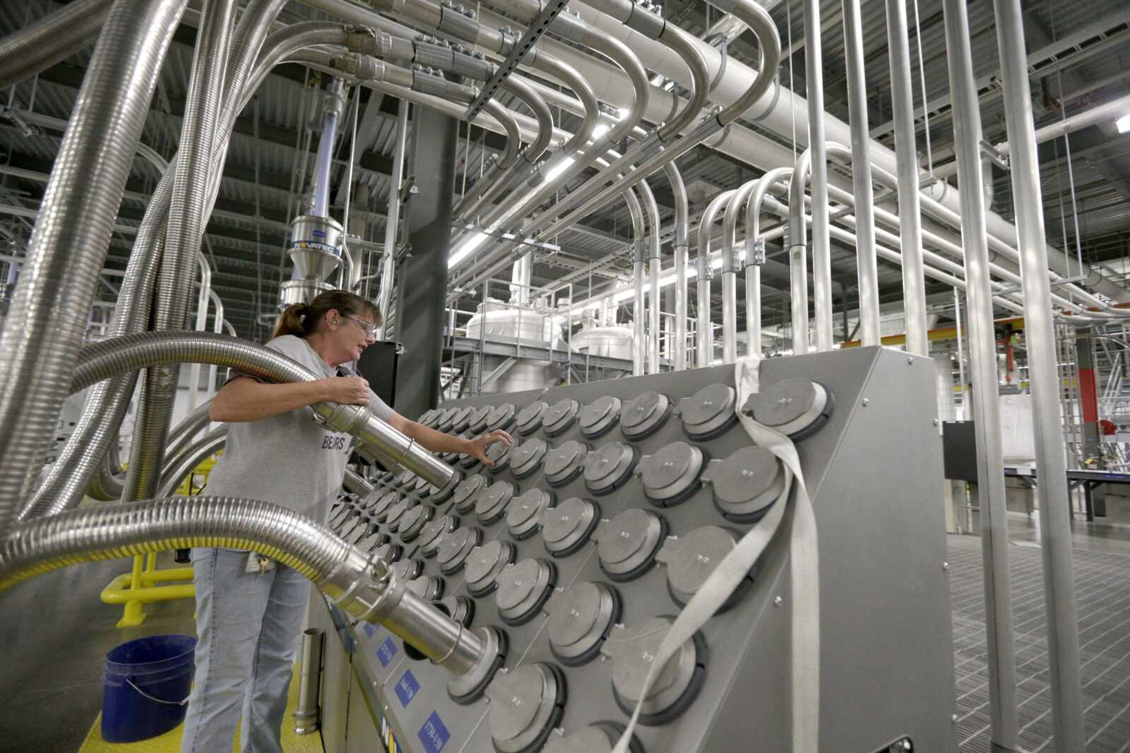 Susan Stacy moves a tube to sort recycled plastic bottle chips being processed at the Repreve Bottle Processing Center, part of the Unifi textile company in Yadkinville, North Carolina.