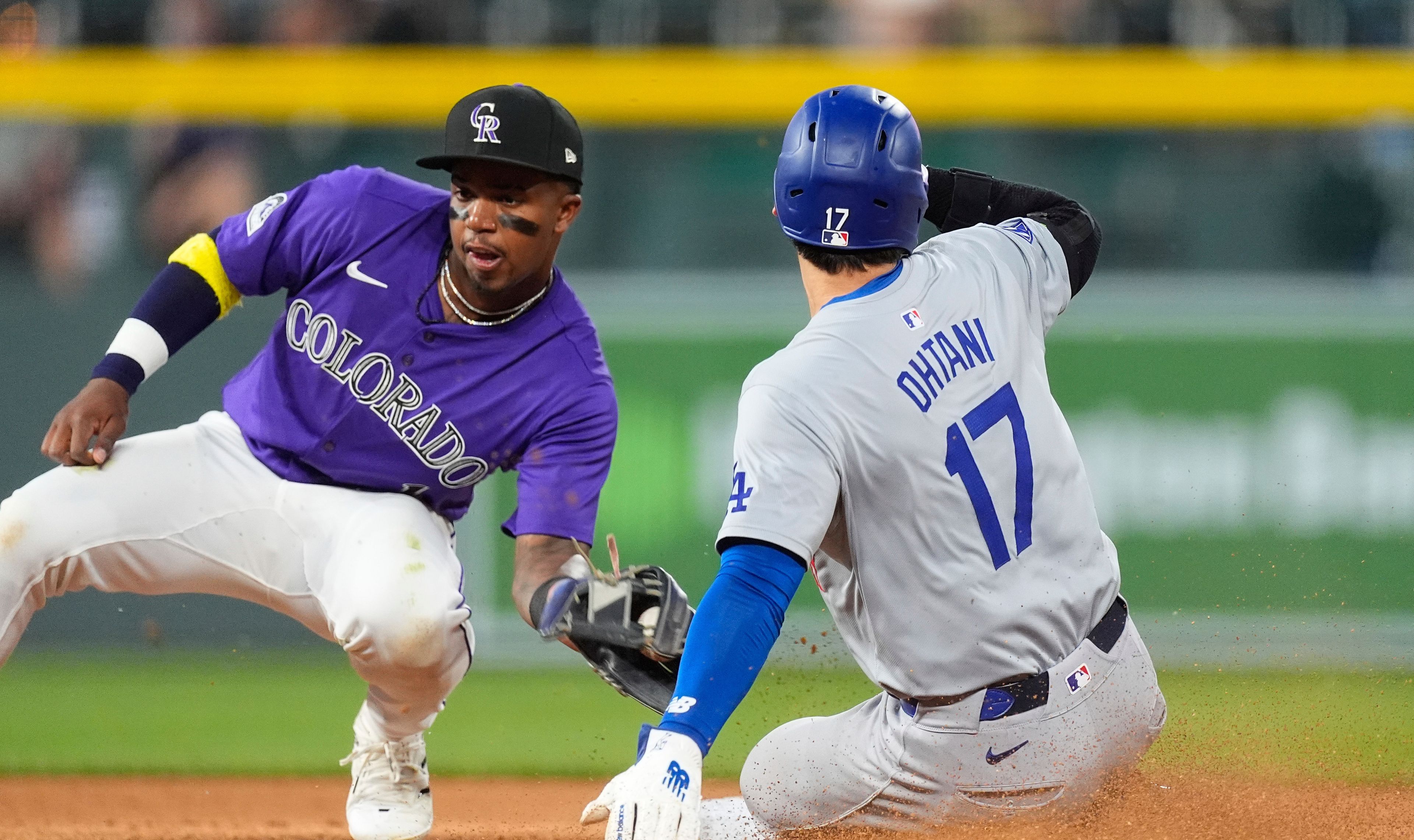 Los Angeles Dodgers' Shohei Ohtani, right, slides safely into second base for a steal as Colorado Rockies second baseman Adael Amador, left, fields the throw in the eighth inning of a baseball game Monday, June 17, 2024, in Denver. (AP Photo/David Zalubowski)