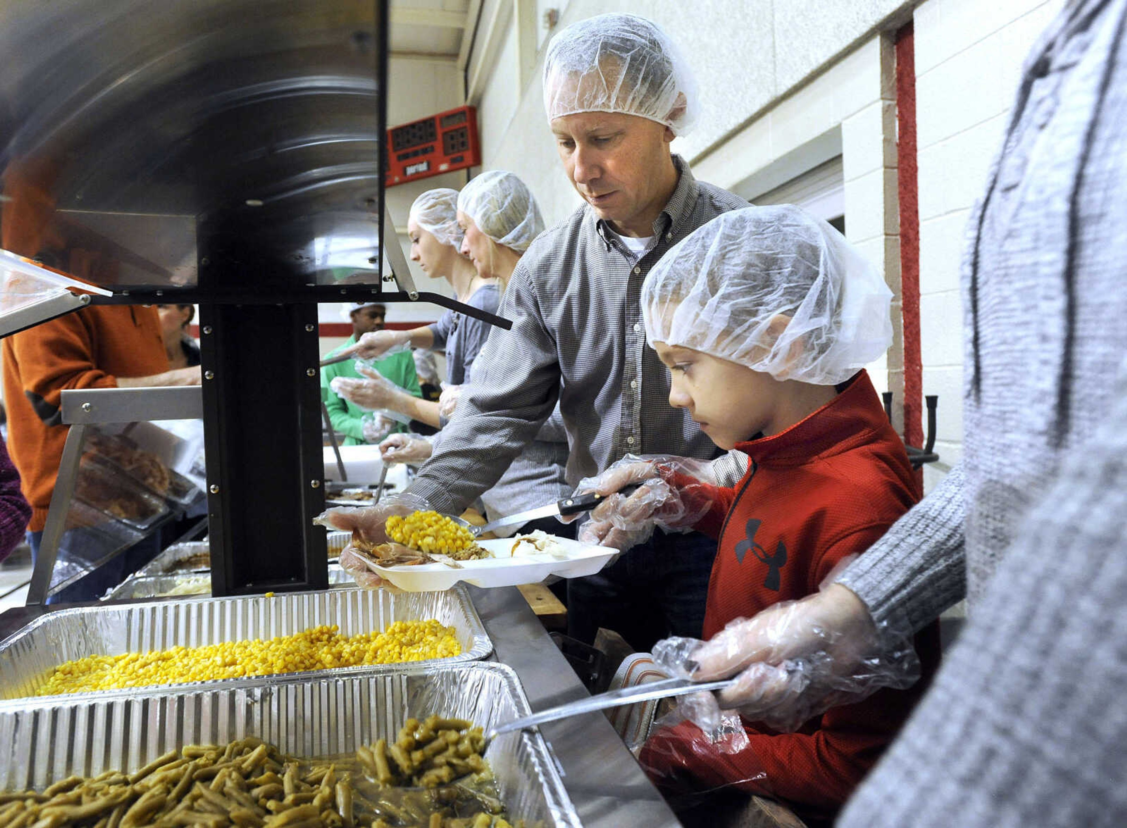 FRED LYNCH ~ flynch@semissourian.com
Kris Outman and his son, Jack Henry Outman, work in the serving line Thursday, Nov. 23, 2017 with their family for the Thanksgiving Day luncheon at the Salvation Army in Cape Girardeau.