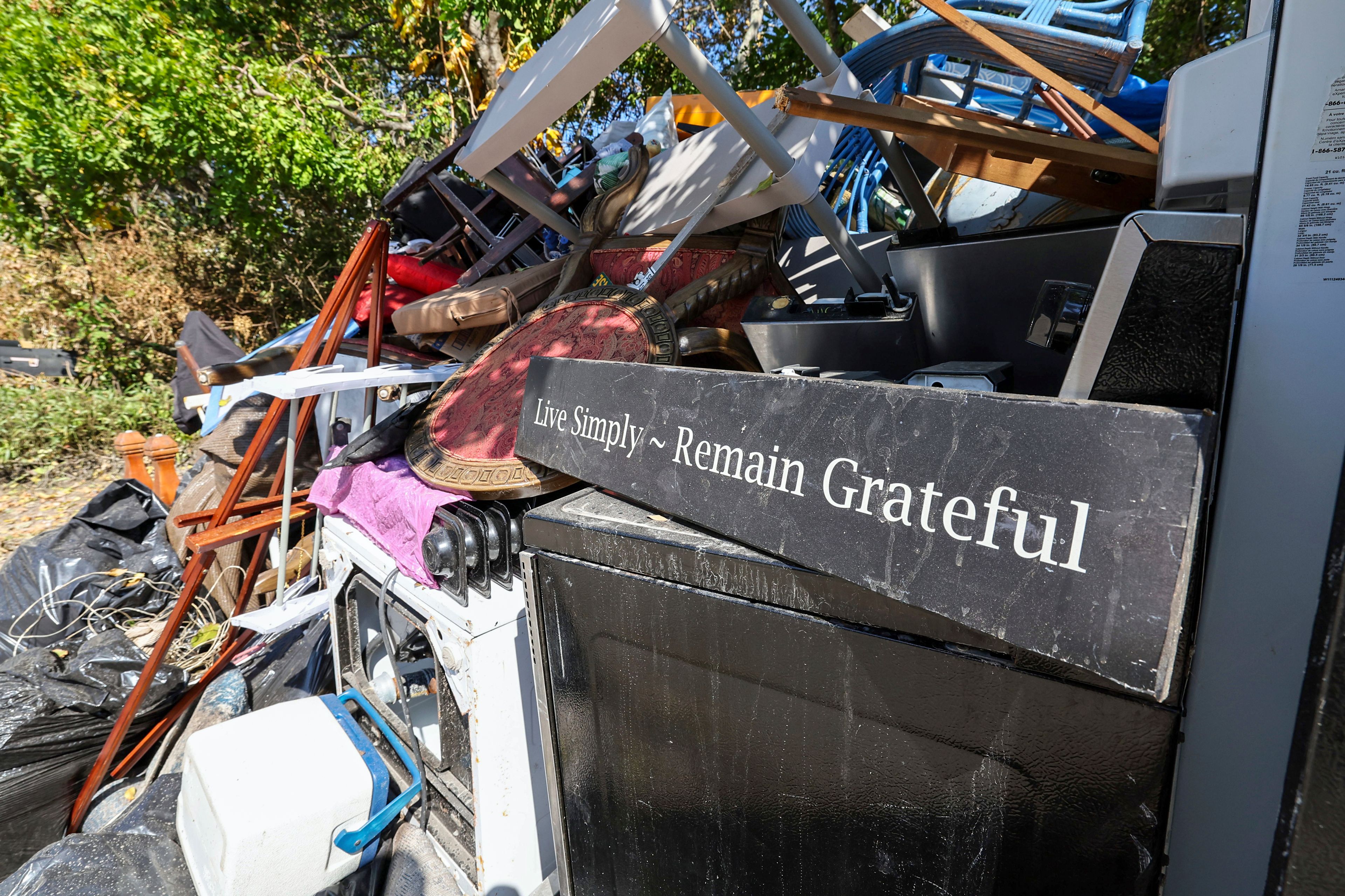 Contents of a home are piled on the side of a home after flooding from Hurricane Helene on Wednesday, Oct. 2, 2024, in Indian Rocks Beach, Fla. (AP Photo/Mike Carlson)