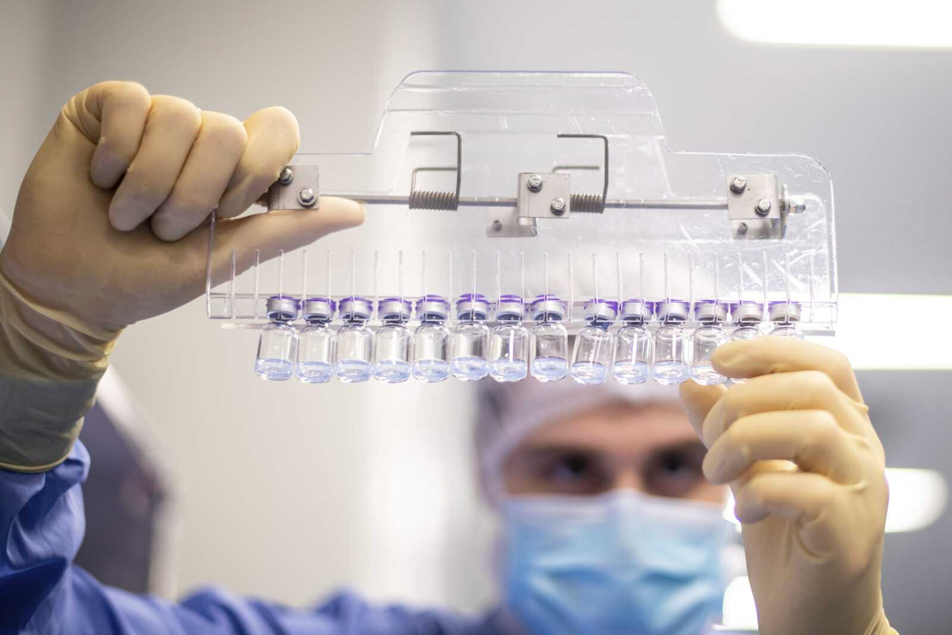 A technician inspects filled vials of the Pfizer- BioNTech COVID-19 vaccine in March at the company's facility in Puurs, Belgium.