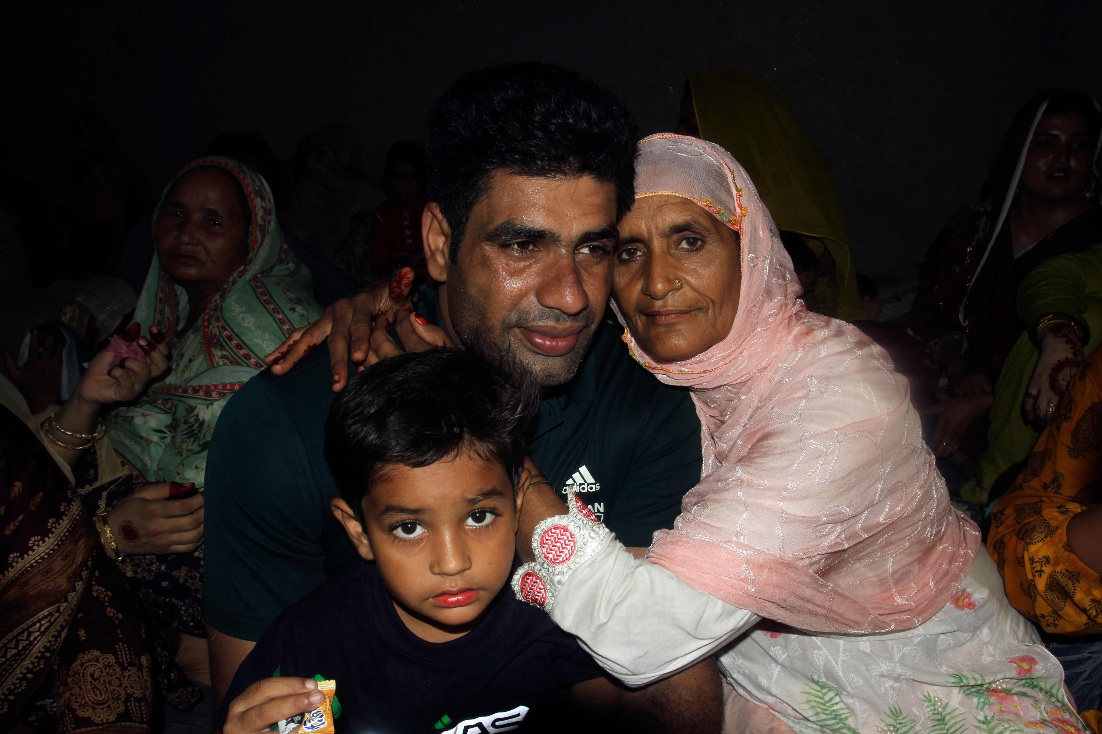 Men's javelin gold medalist, Arshad Nadeem, of Pakistan poses for a photograph with his mother inside his house, in Mian Channu, Khanewal district, of Pakistan, Sunday, Aug. 11, 2024. (AP Photo/Asim Tanveer)