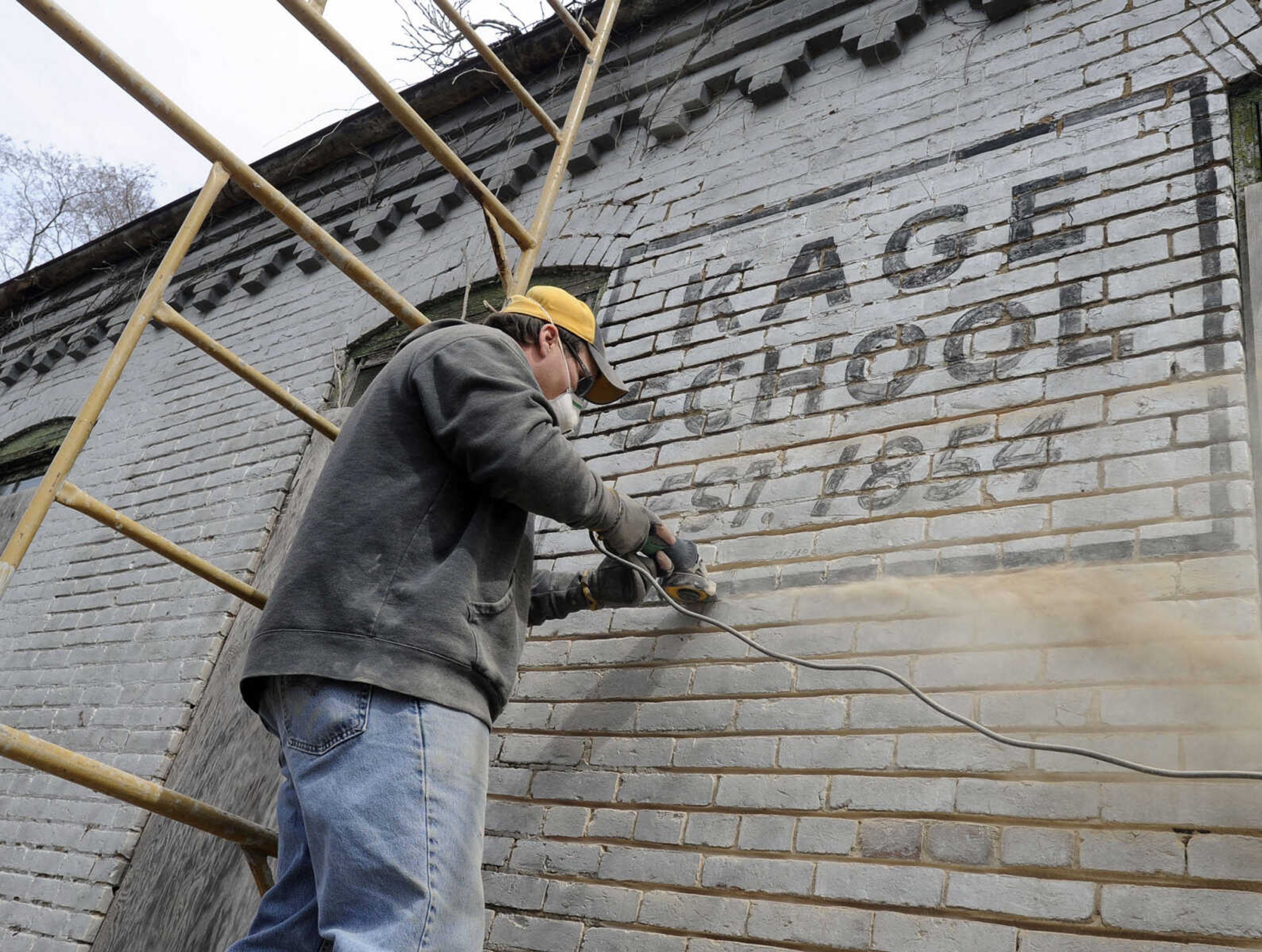 FRED LYNCH ~ flynch@semissourian.com
Justin Wissmann with Langston Masonry & Construction grinds out joints in the brick wall of the old Kage School in preparation for tuckpointing on Monday, March 24, 2014 in Cape Girardeau. The building's owner, Rick Hetzel, said he bought the former one-room school from Keith Deimund and plans to repurpose it into a 2-bedroom home. The building itself dates from 1880, replacing a log structure that stood since 1854. Classes continued until 1966. Hetzel plans to restore the building consistent with historical guidelines. The classroom area will remain open and a loft bedroom will be added above the kitchen area. Indoor plumbing will also be added. Hetzel plans to have an open house within a couple of months before the repurposing construction begins.