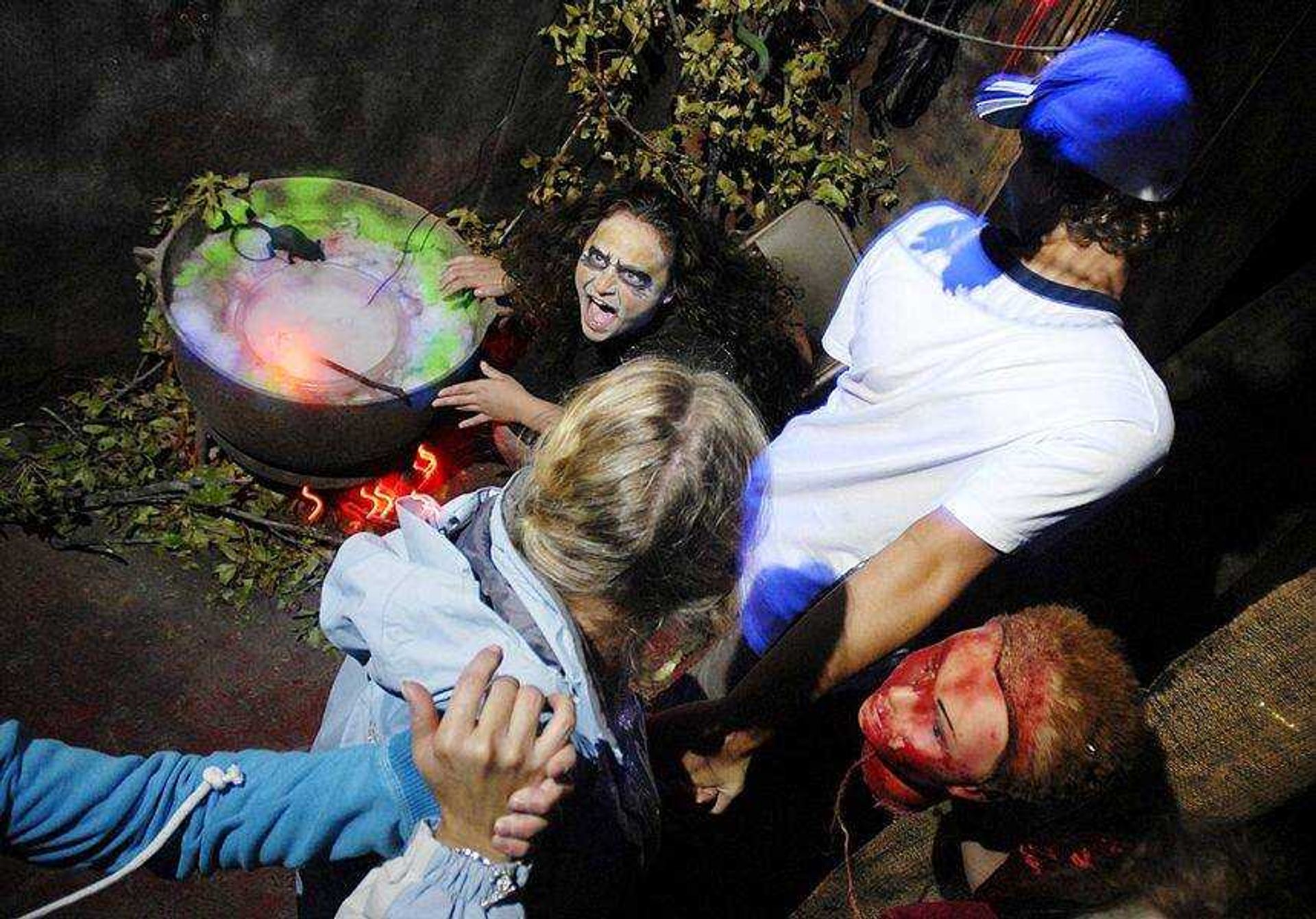 Hunter Urhahn holds the hand of his aunt, Susie Hallgren, while she holds the hand of his sister Kaelyn Urhahn as they move past a witch in the Haunted Hall of Horror on Oct. 20, 2007.