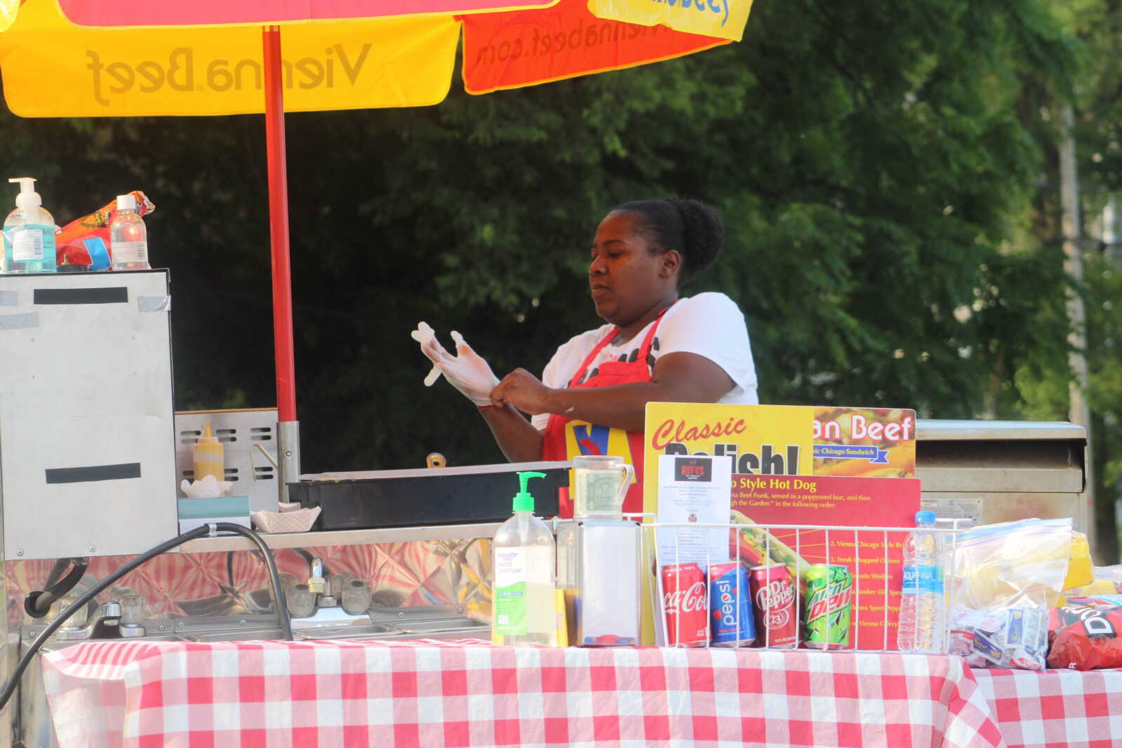 An employee working the Chicago Vienna Beef stand puts on her gloves and prepares hotdogs during the Cape Broadway Theatre Festival on Saturday, July 18, 2021, in the parking lot on the northeast corner of Broadway and Pacific Street in Cape Girardeau.