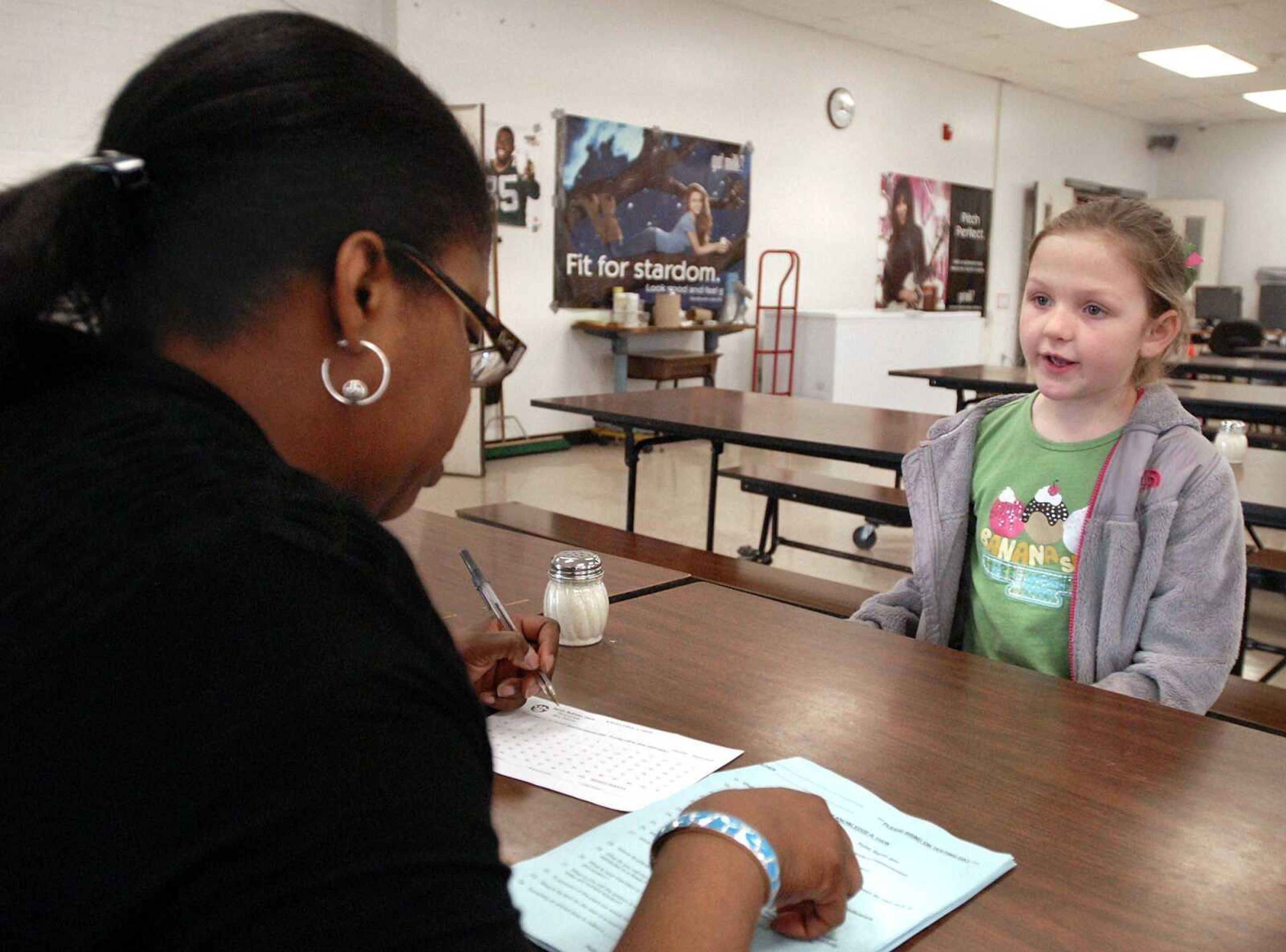 Monique Johnson quizzes Alma Schrader third-grader Sarah McKinley Davis on Wednesday during the schoolwide Knowledge-A-Thon. The event is a fundraiser for the Parent Teacher Organization. (Laura Simon)