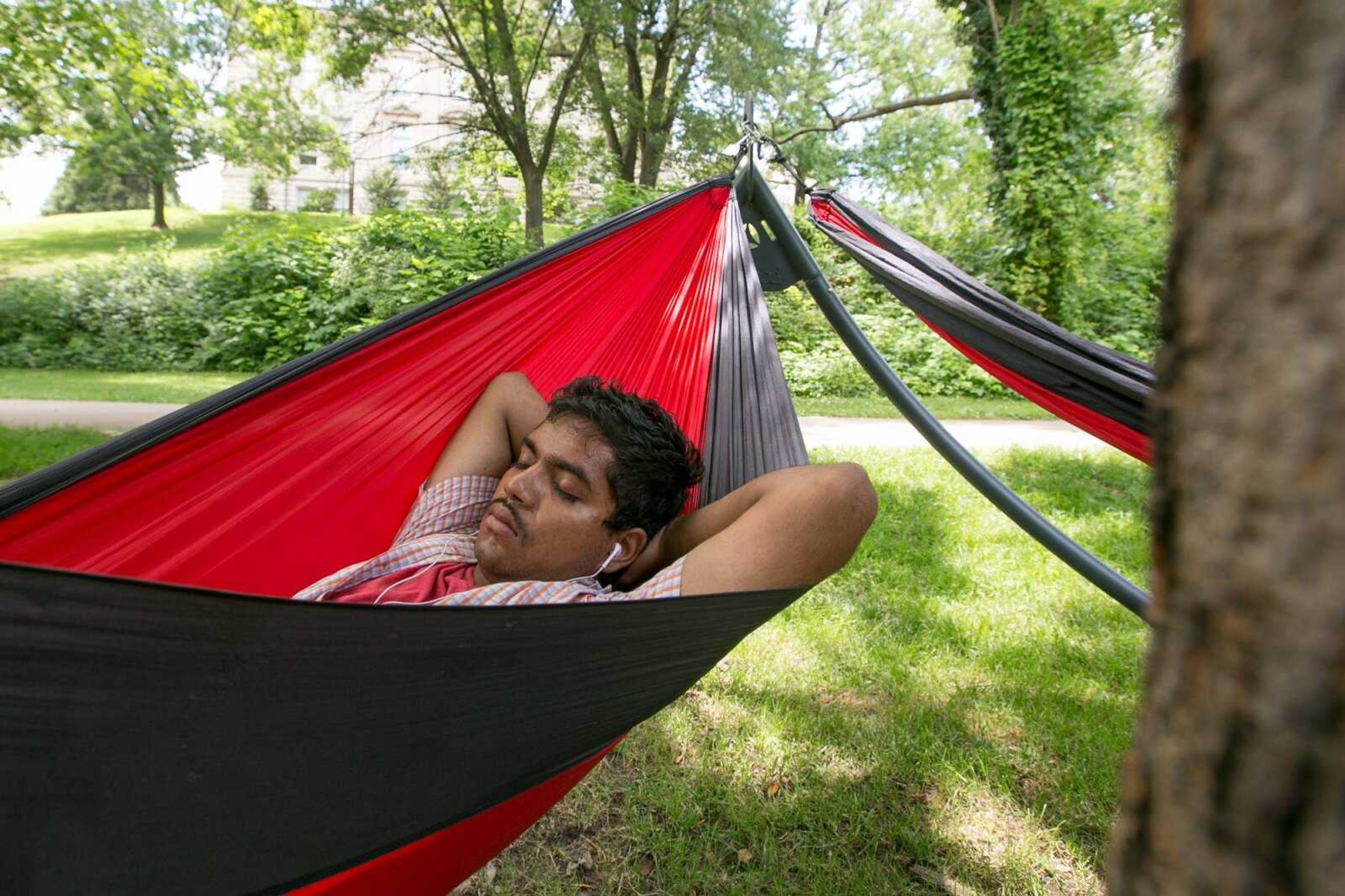 Naveen Palthya, a ticket writer for the Department of Public Safety at Southeast Missouri State University, takes a break in one of nine hammocks set up next to Academic Hall on Wednesday.