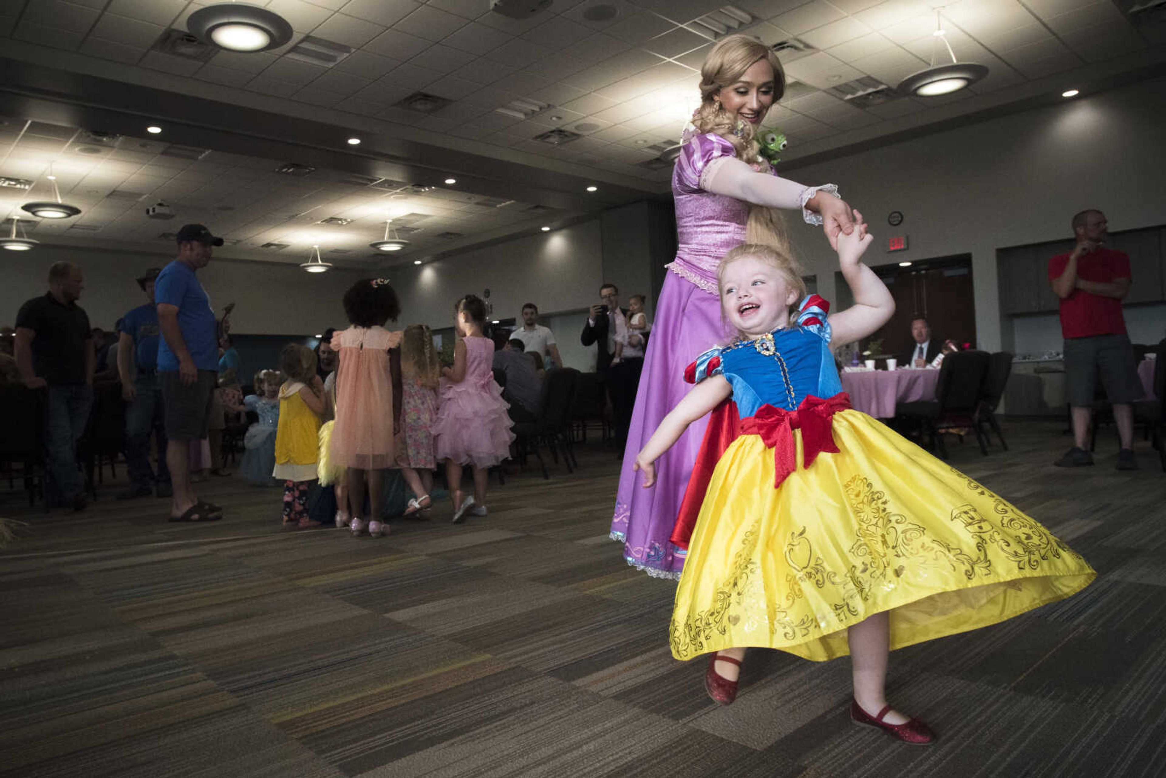 Payton Foltz, 3, of Patton, Missouri, is twirled by Hannah Duke, dressed as Rapunzel, during a Chick-Fil-A Daddy Daughter Tea Party held Thursday, July 18, 2019, at the Jackson Civic Center.