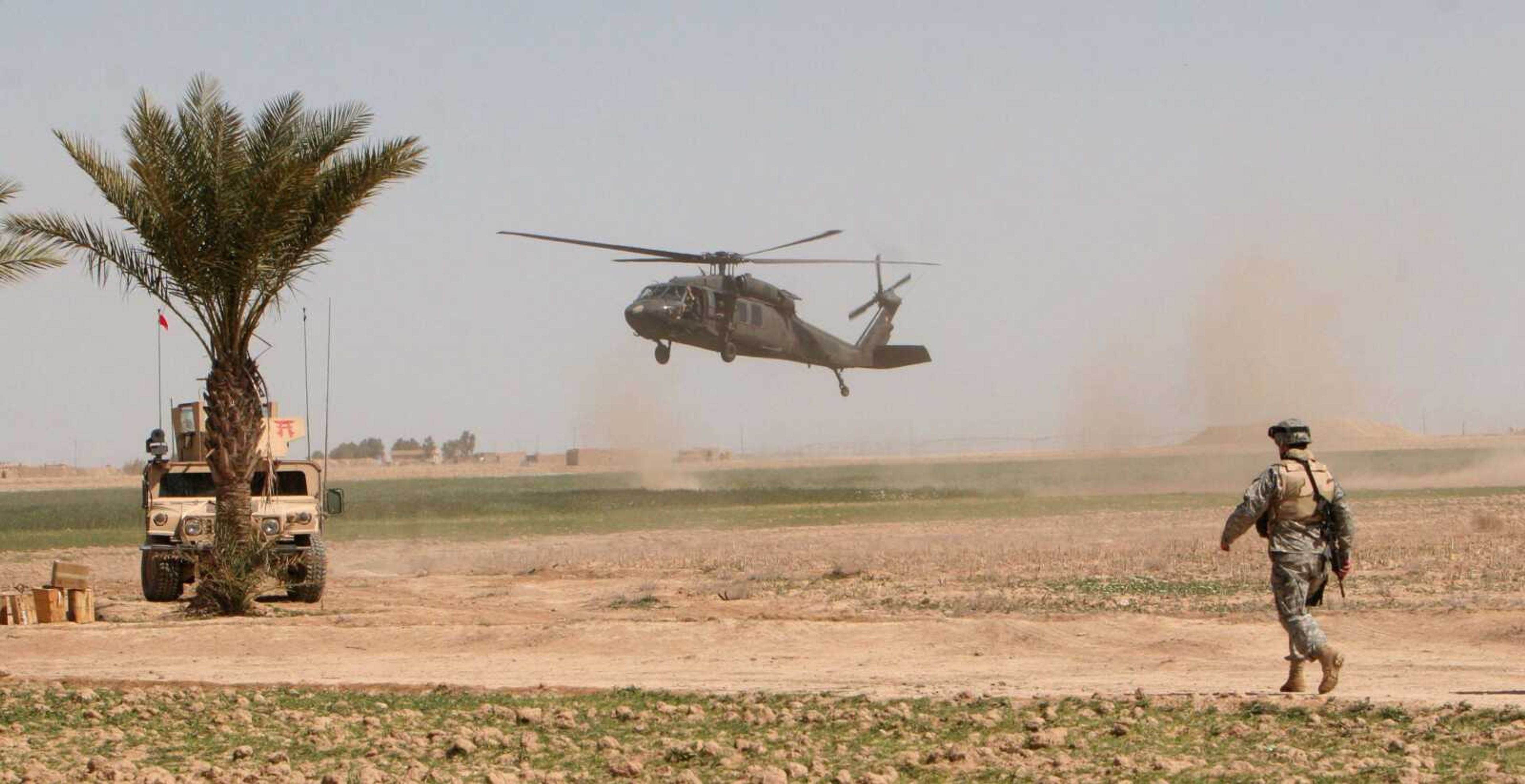 A U.S. helicopter lands in the field as a U.S. soldier stands guard March 17, 2006, outside Samarra, Iraq. The White House is planning to keep up to 10,000 troops in Iraq next year. (Associated Press file)