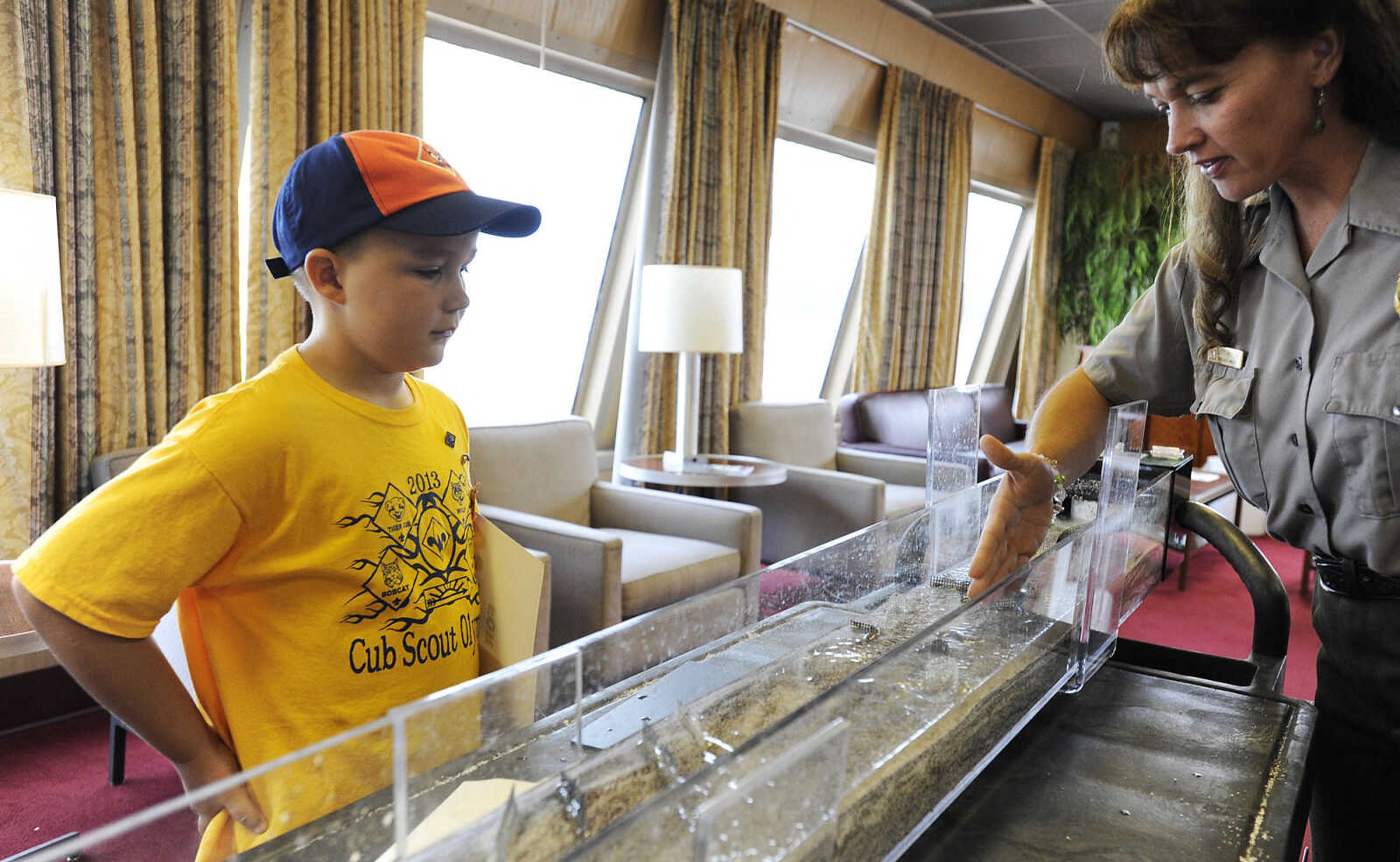 Jane Mifflin of the U.S. Army Corp of Engineers, shows Pierce Bisher, 7, how the flow of a river can be changed by structures placed in it during a tour of the Motor Vessel Mississippi Saturday, Aug. 17, at Riverfront Park in Cape Girardeau. The 241 foot-long towboat is stationed in the Corps of Engineers' Memphis District and spends 90% of its time moving barges, equipment and supplies on the Mississippi River. Built in 1993 the M/V Mississippi is the largest towboat in the U.S. and the fifth Corps of Engineers vessel to bear the name Mississippi.