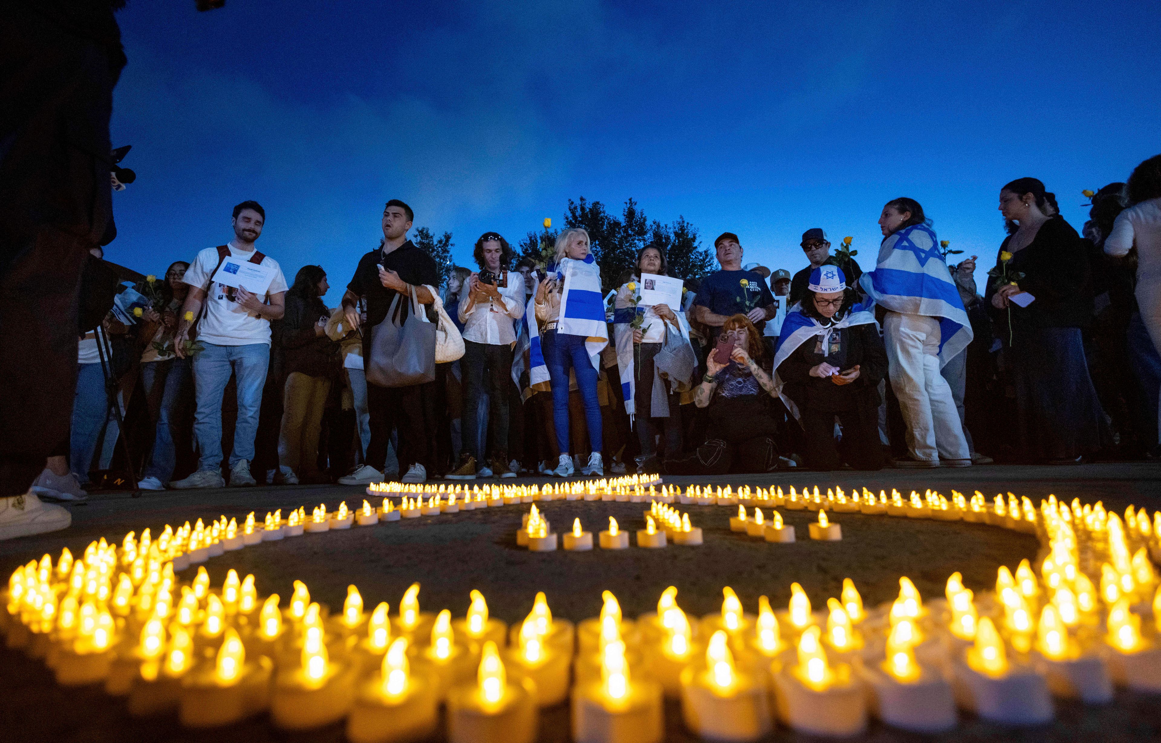 People gather for a candlelight vigil at the UCLA campus on the one-year anniversary of the Hamas attack on Israel, Monday, Oct. 7, 2024, in Los Angeles. (AP Photo/Ethan Swope)