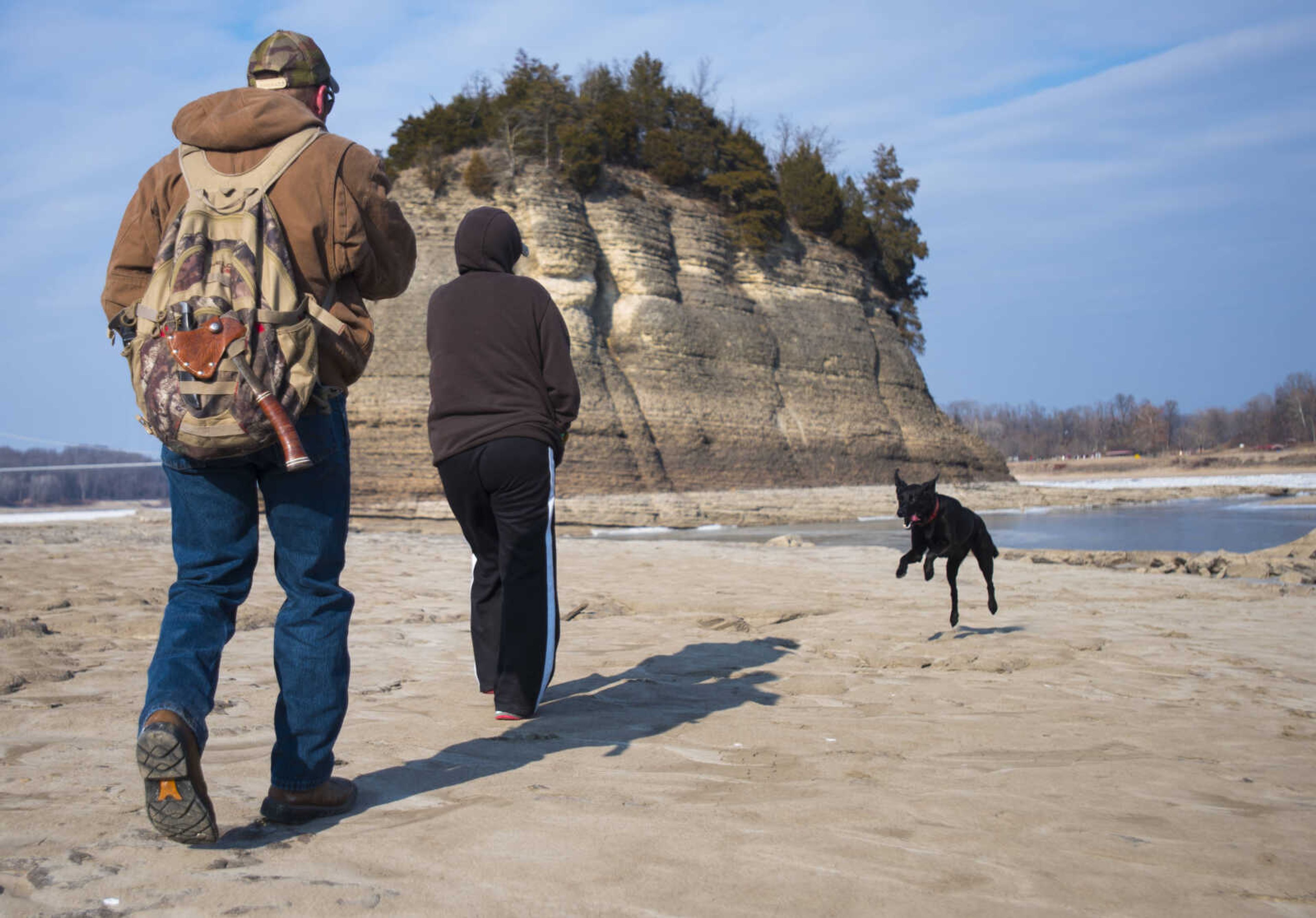 Accompanied by his dog, Rocket, Josh Engert of Altenburg, Missouri, and Sara Dippold of Perryville, Missouri, view frozen Mississippi River waters surrounding Tower Rock on Jan. 5, 2018, in Perry County, Missouri.