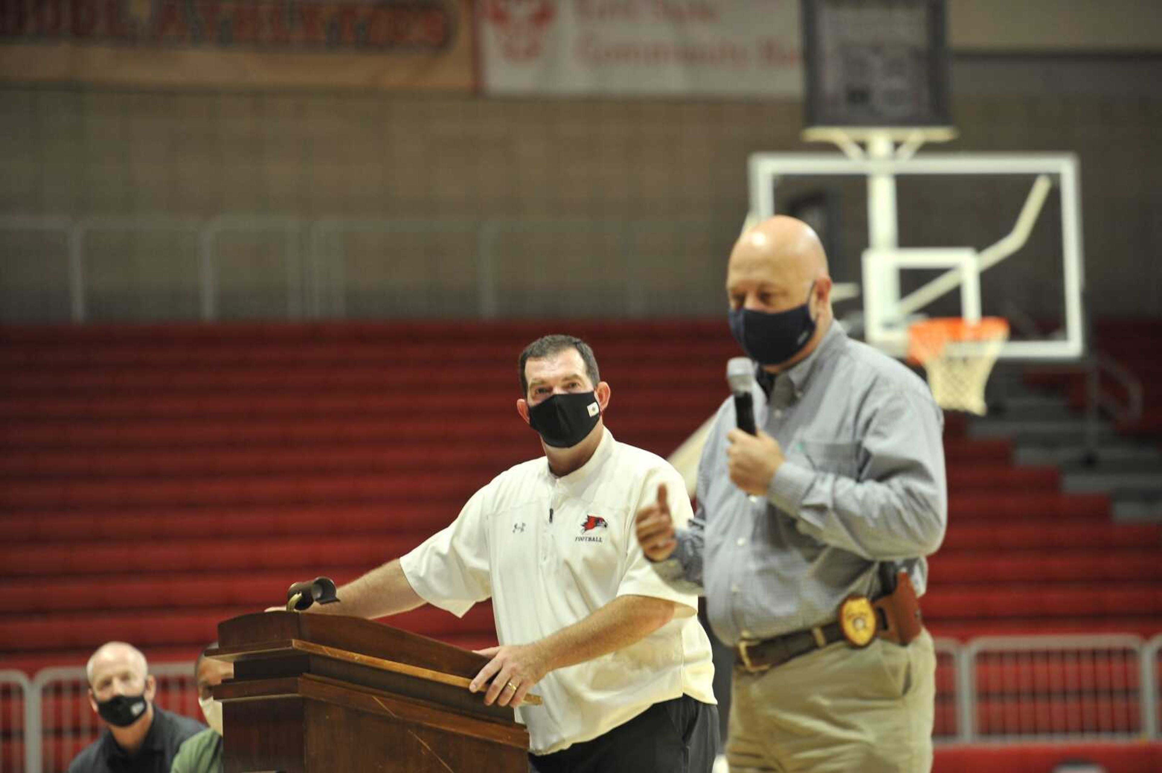 Southeast Missouri State University football coach Tom Matukewicz, left, listens to Cape Girardeau police chief Wes Blair speak to Redhawk players and coaches last month at the Show Me Center.