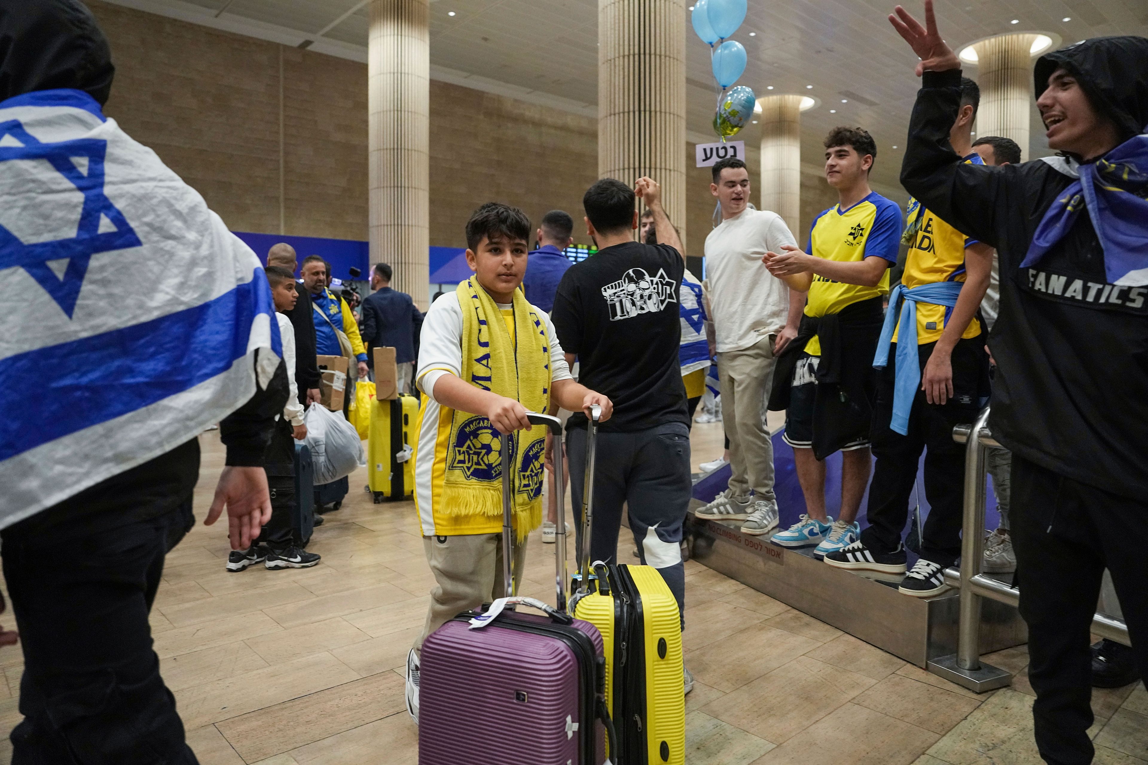 People welcome Maccabi Tel Aviv soccer fans as they arrive at Israel's Ben-Gurion International Airport on a flight from Amsterdam, where Israeli soccer fans were attacked following a match between the Israeli club and Ajax Amsterdam, in Lod, Israel, Friday, Nov. 8, 2024. (AP Photo/Tsafrir Abayov)