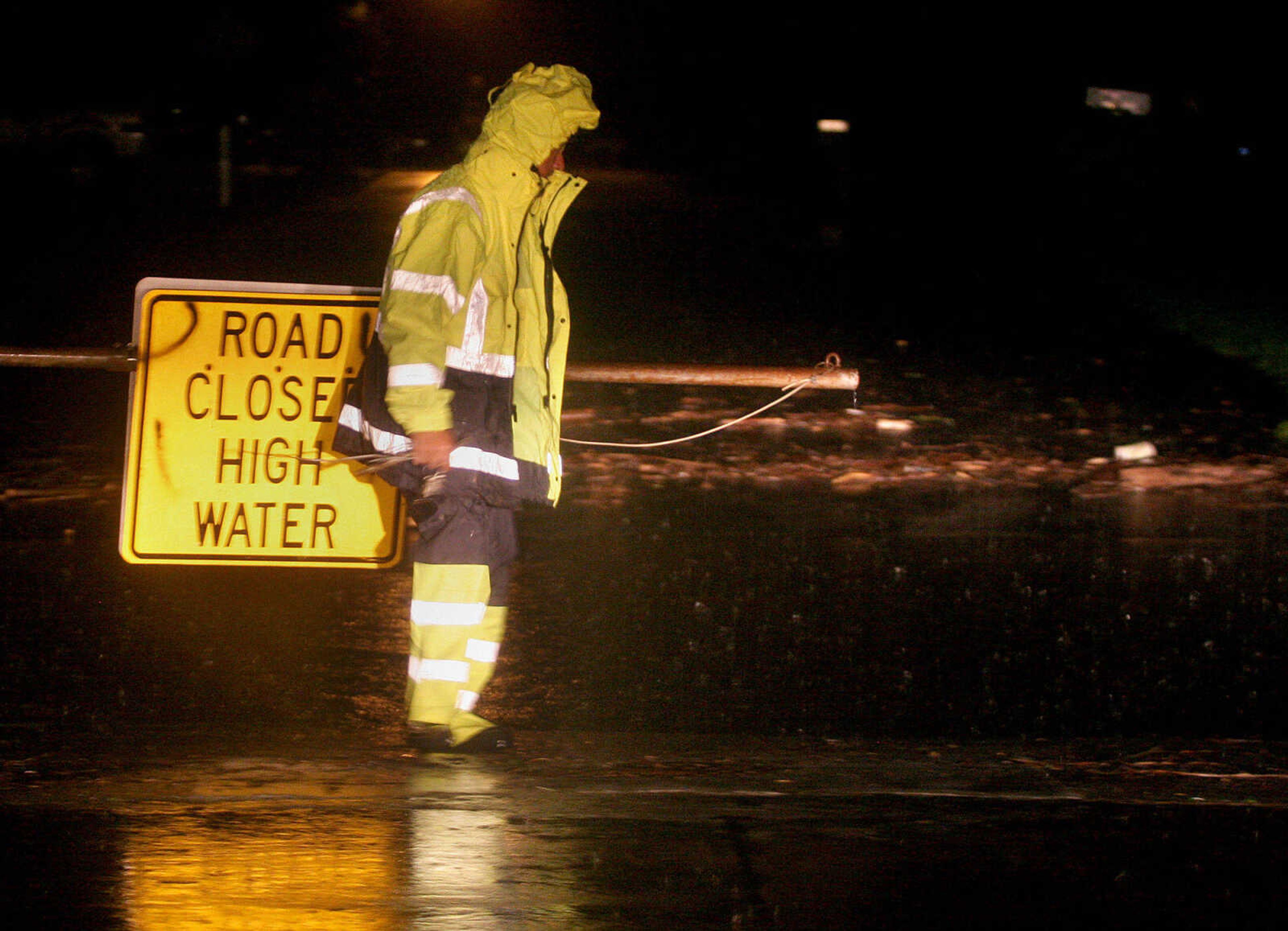 ELIZABETH DODD ~ edodd@semissourian.com
Jim Edmundson, city public works worker, closes a gate to prevent traffic from crossing through high water Tuesday night on Howell Street.