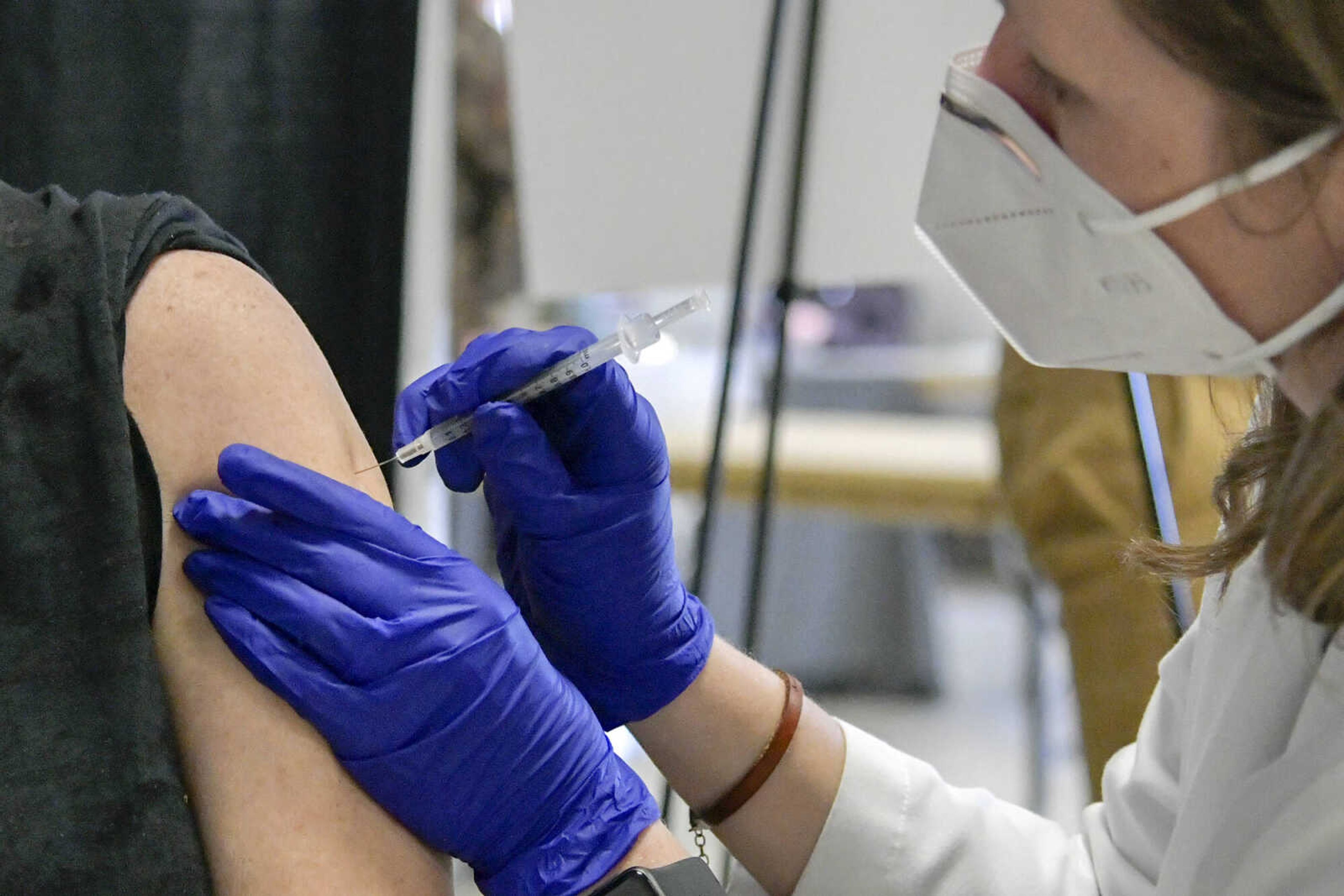 From left, Joy Baldwin receives her first dose of the Pfizer-BioNTech vaccine from pharmacist Catherine Heaton at the 4H Building in Arena Park in Cape Girardeau on Monday, Jan. 18, 2021.