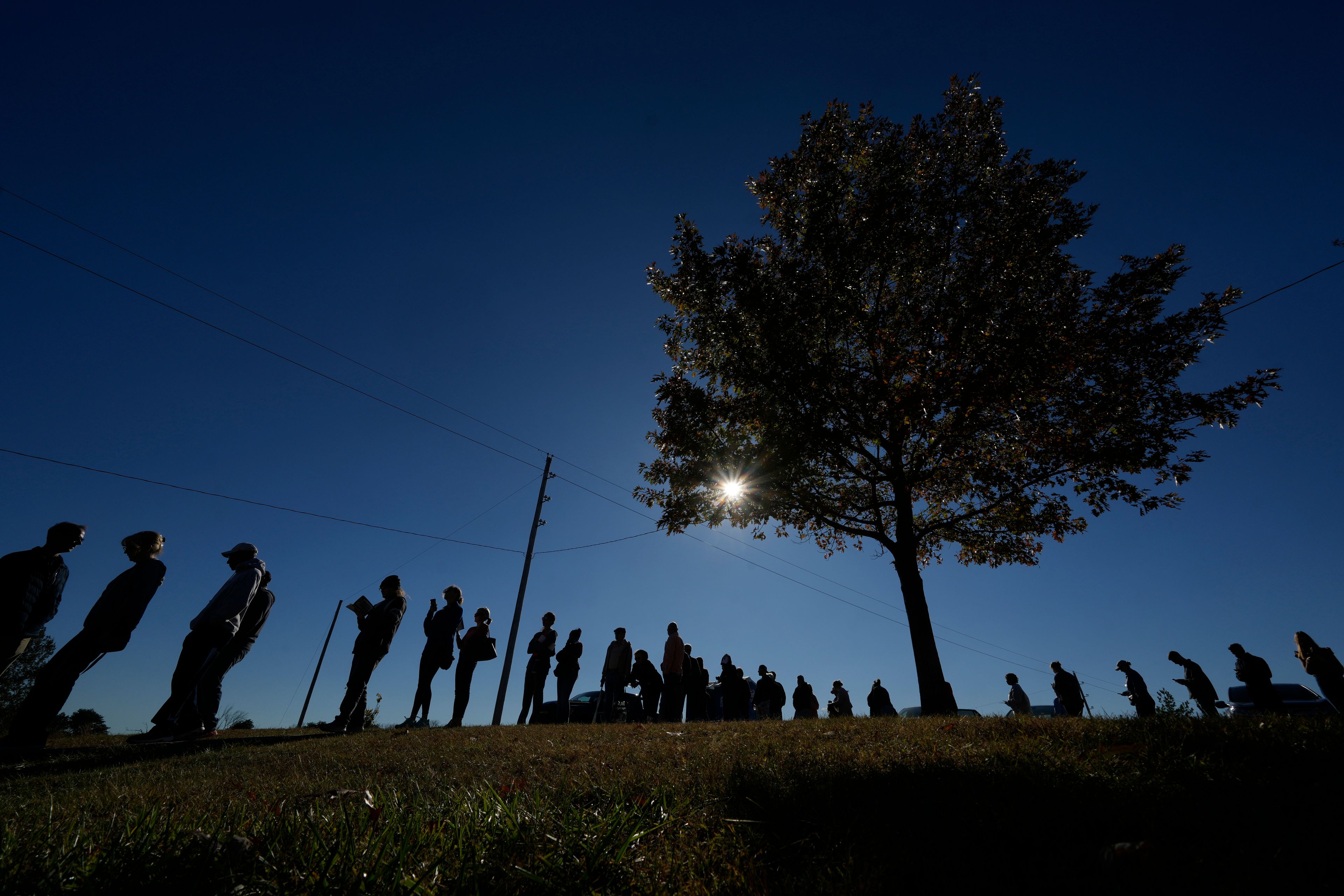 People wait in line to cast their ballots at an early voting location, Thursday, Oct. 31, 2024, in Blue Springs, Mo. (AP Photo/Charlie Riedel)