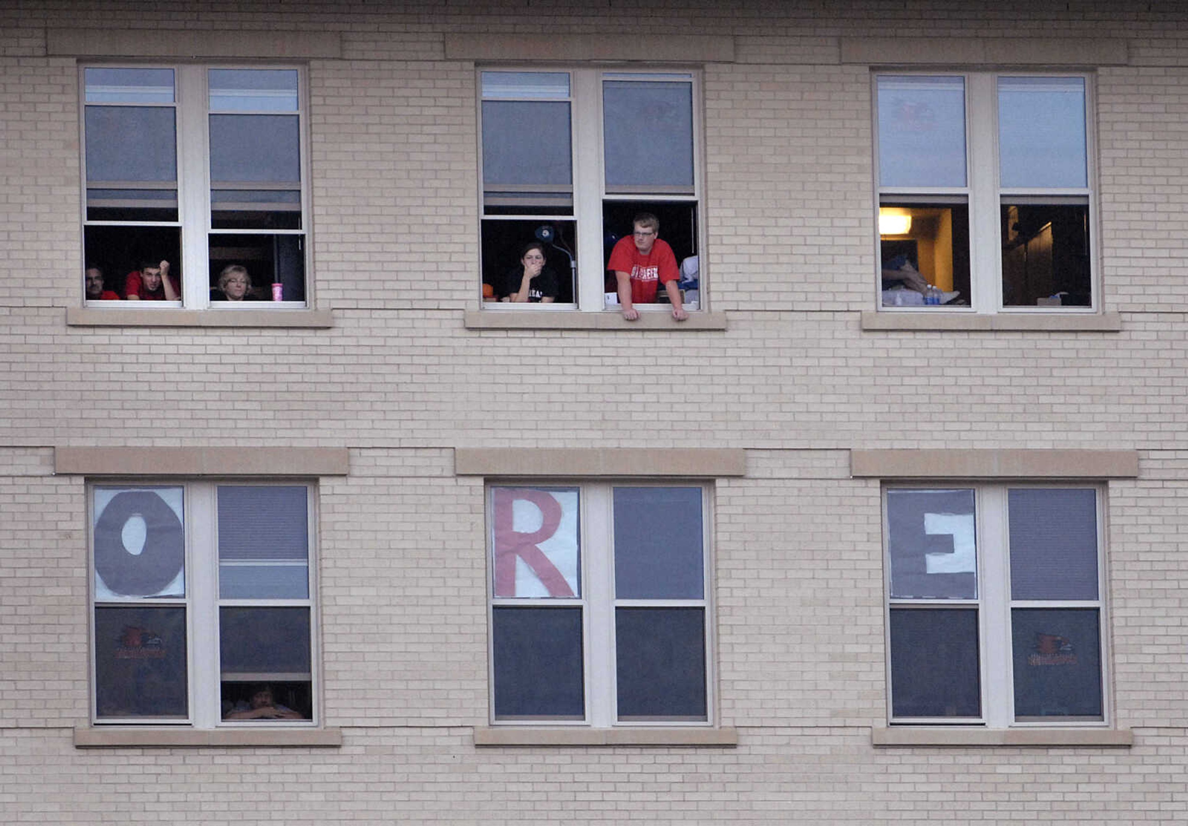 Students watch the football game from their rooms in New Hall.